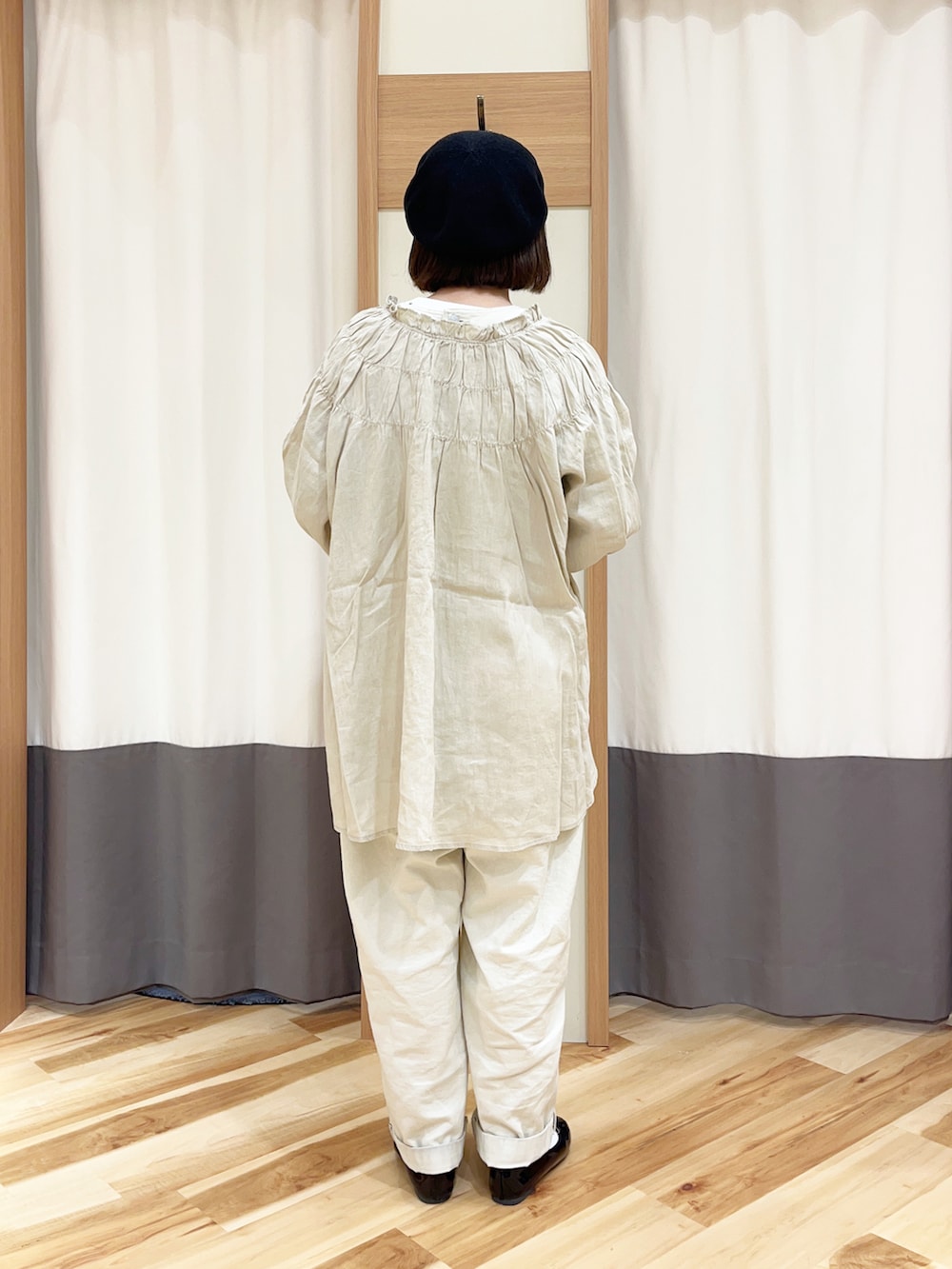 ホワイト系のデニムパンツ、ブラック系のTシャツ/カットソー、ホワイト系のチュニックを着用したレディースの春コーディネートの2枚目の写真