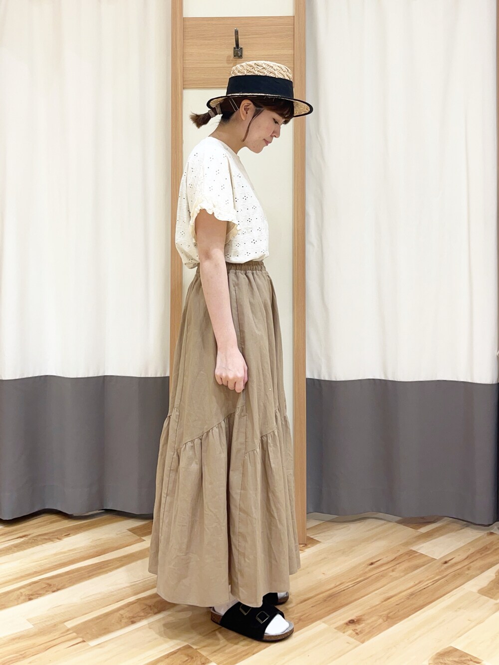 ホワイト系のTシャツ/カットソー、ベージュ系のスカート、ブラック系のハットを着用したレディースの夏コーディネートの2枚目の写真