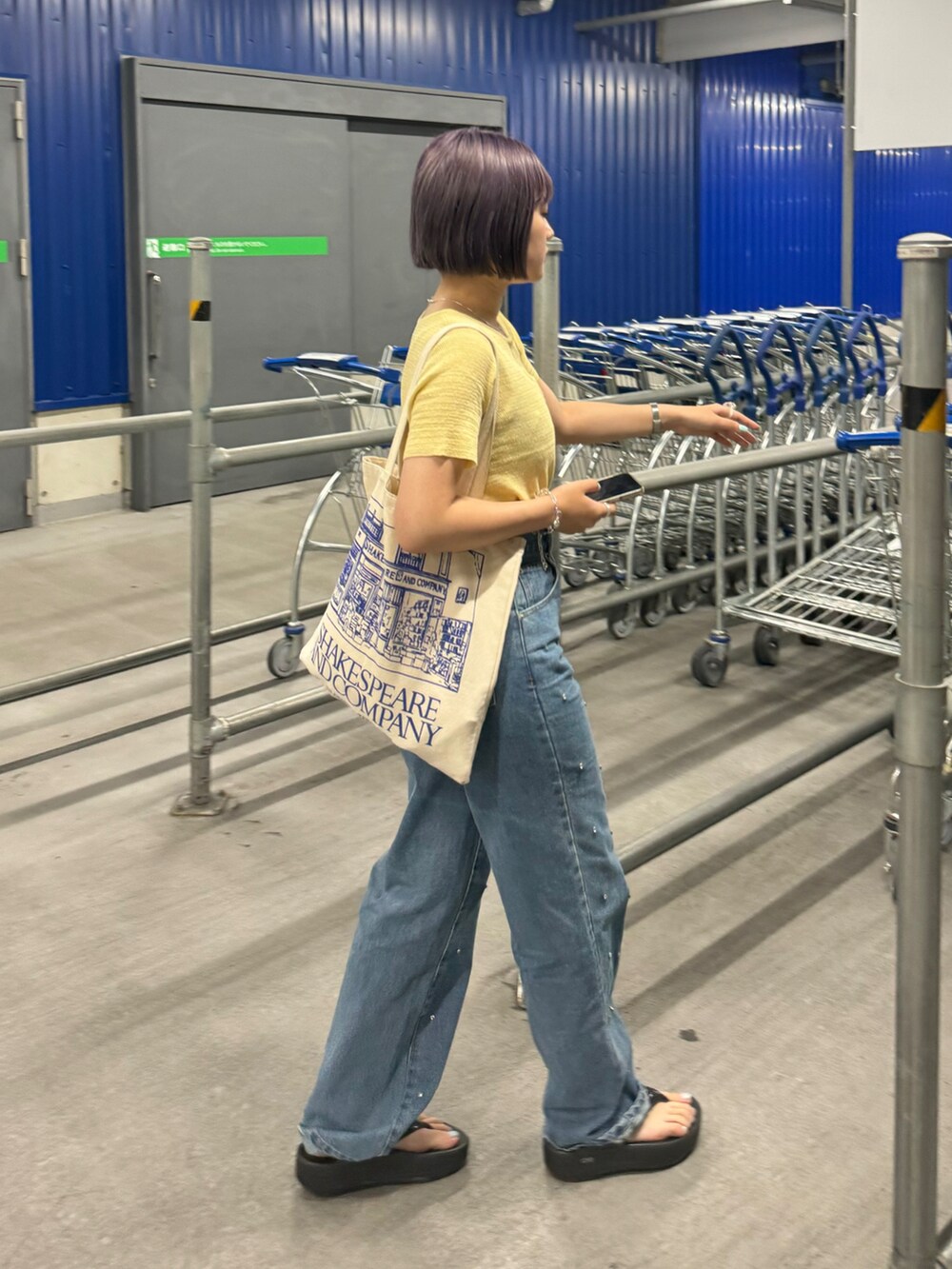 ブラック系のサンダル、ブルー系のデニムパンツ、イエロー系のTシャツ/カットソーを着用したレディースの夏コーディネートの2枚目の写真