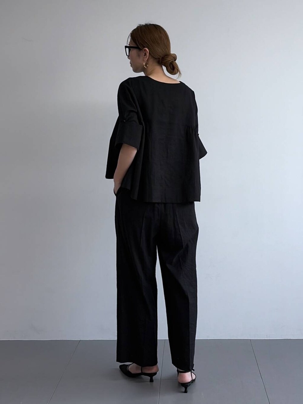 ブラック系のその他パンツ、ブラック系のシャツ/ブラウス、ブラック系のパンプスを着用したレディースの冬コーディネートの2枚目の写真