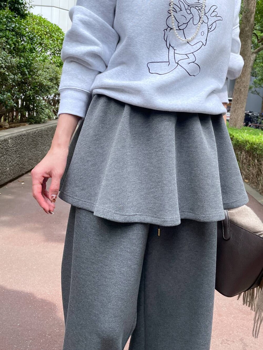 ベージュ系のスニーカー、グレー系のスウェットパンツ、グレー系のスカートを着用したレディースの秋コーディネートの6枚目の写真