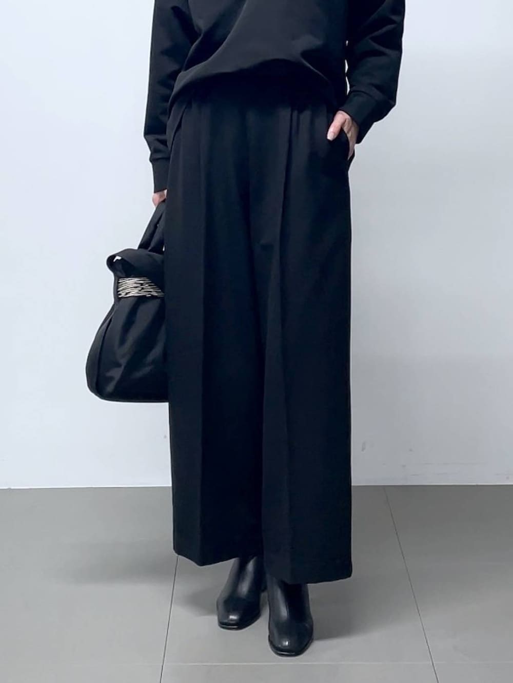 ブラック系のブーツ、ブラック系のシャツ/ブラウス、ブラック系のスラックスを着用したレディースの秋コーディネートの5枚目の写真