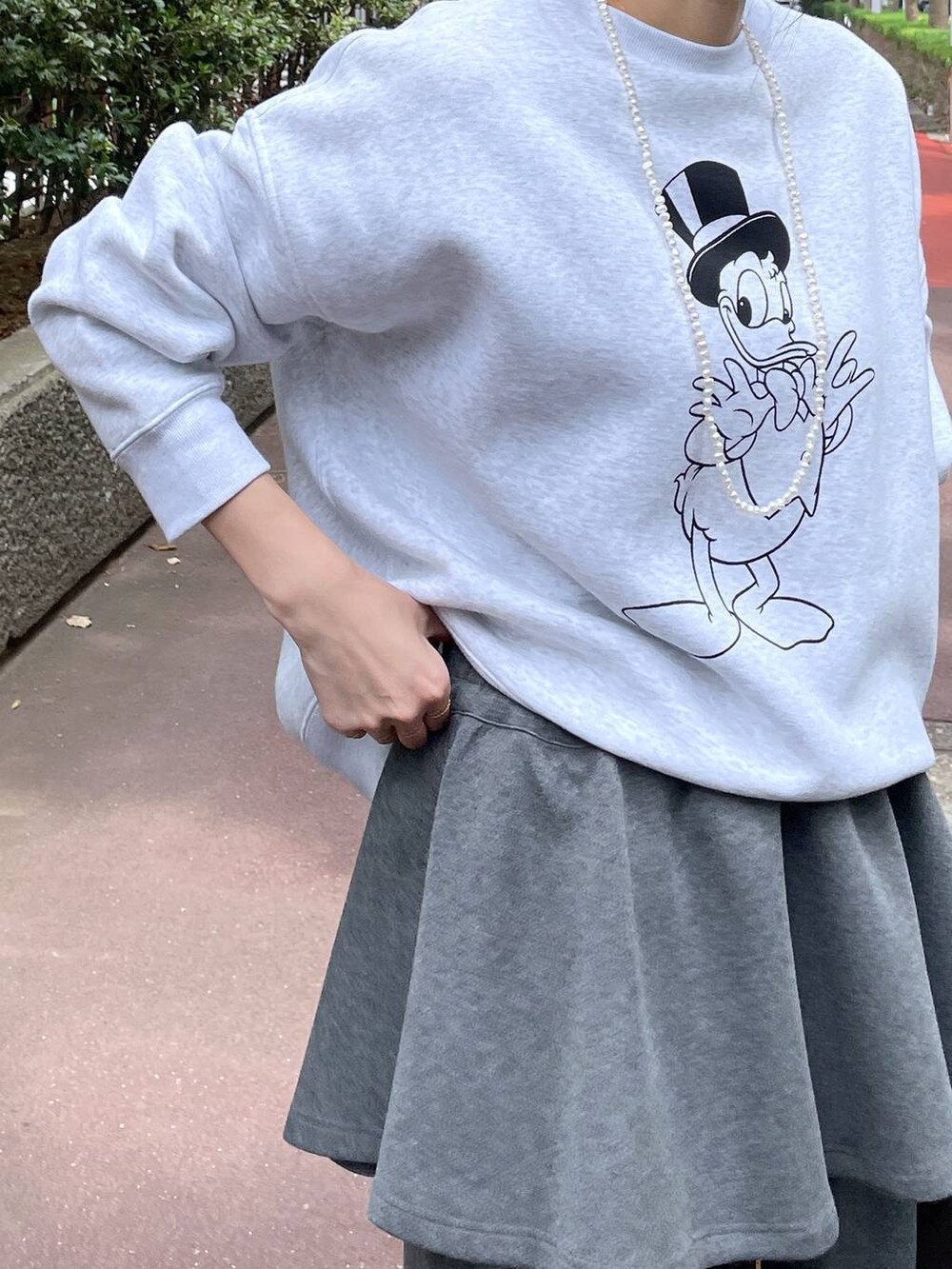 ベージュ系のスニーカー、グレー系のスウェットパンツ、グレー系のスカートを着用したレディースの秋コーディネートの5枚目の写真