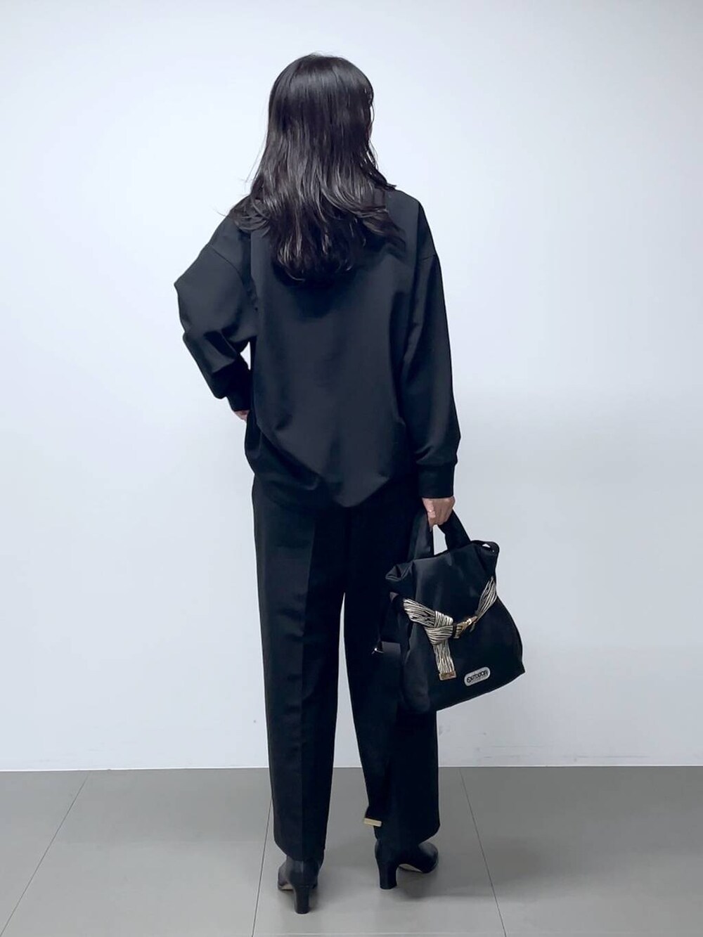 ブラック系のブーツ、ブラック系のシャツ/ブラウス、ブラック系のスラックスを着用したレディースの秋コーディネートの4枚目の写真