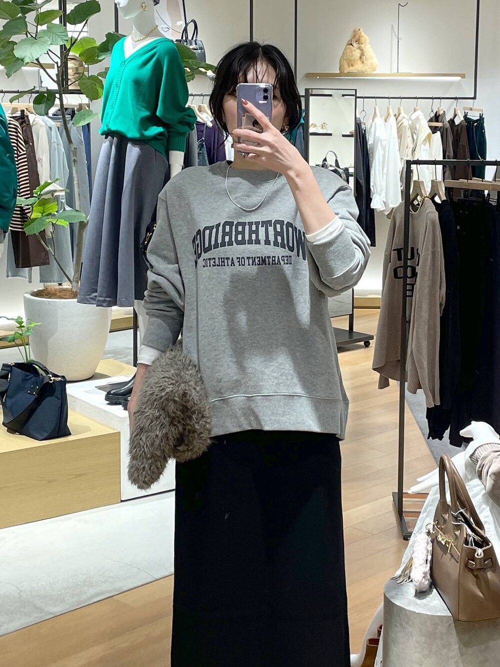ホワイト系のTシャツ/カットソー、ブラック系のスカート、グレー系のスウェットを着用したレディースの秋コーディネートの3枚目の写真