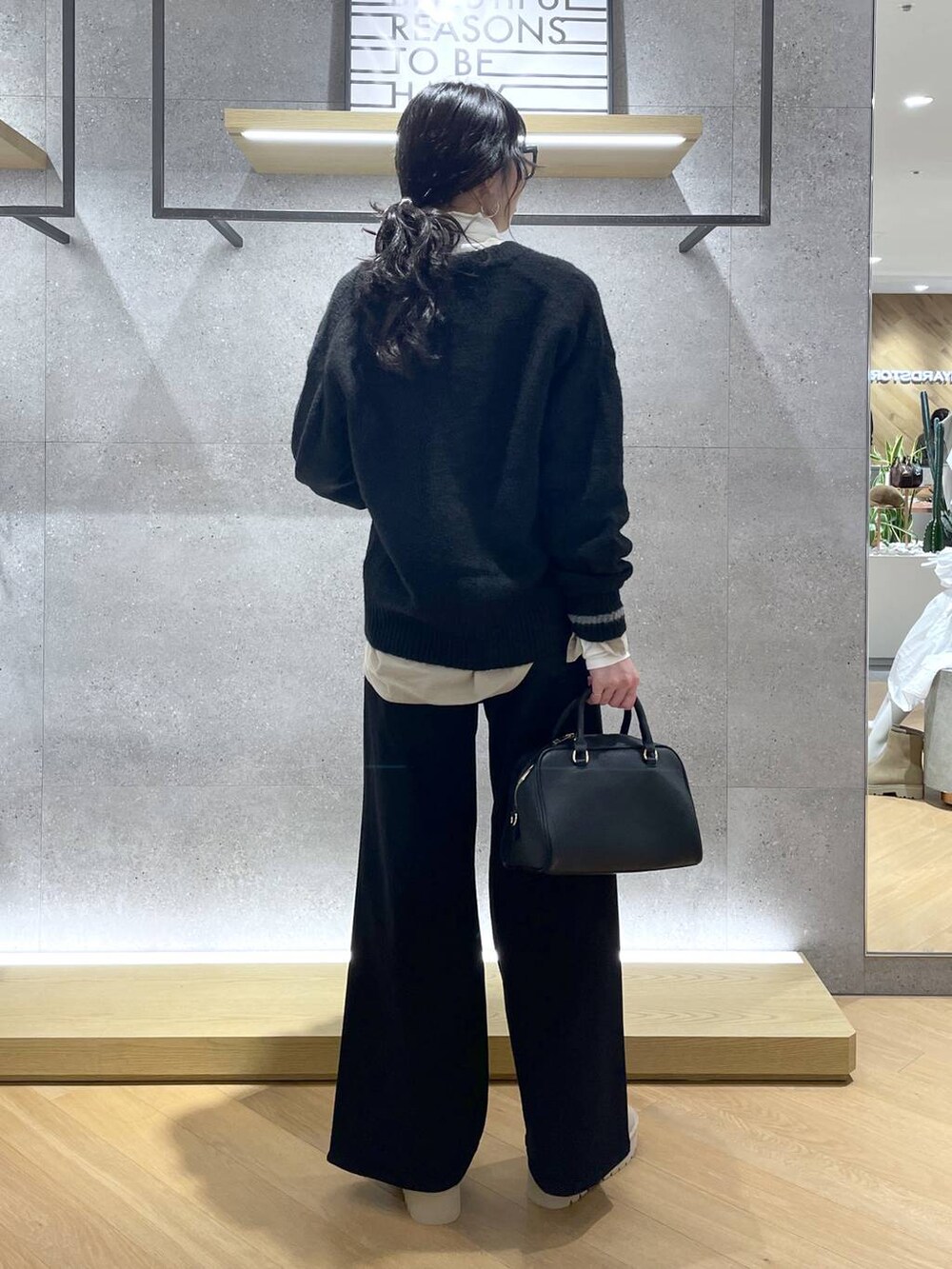 ブラック系のボストンバッグ、ベージュ系のシャツ/ブラウス、ブラック系のデニムパンツを着用したレディースの秋コーディネートの3枚目の写真