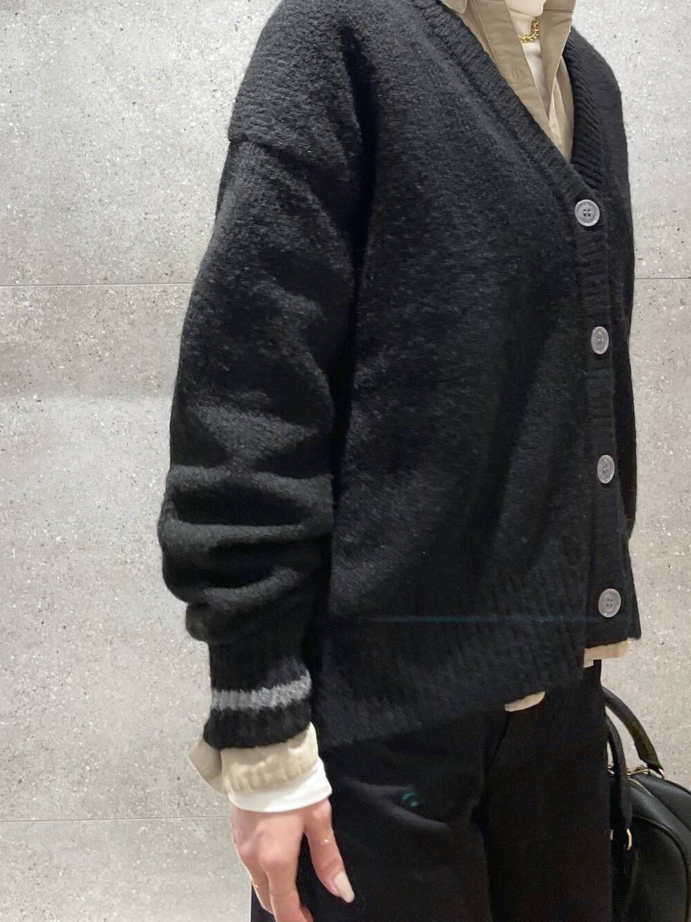 ブラック系のボストンバッグ、ベージュ系のシャツ/ブラウス、ブラック系のデニムパンツを着用したレディースの秋コーディネートの6枚目の写真