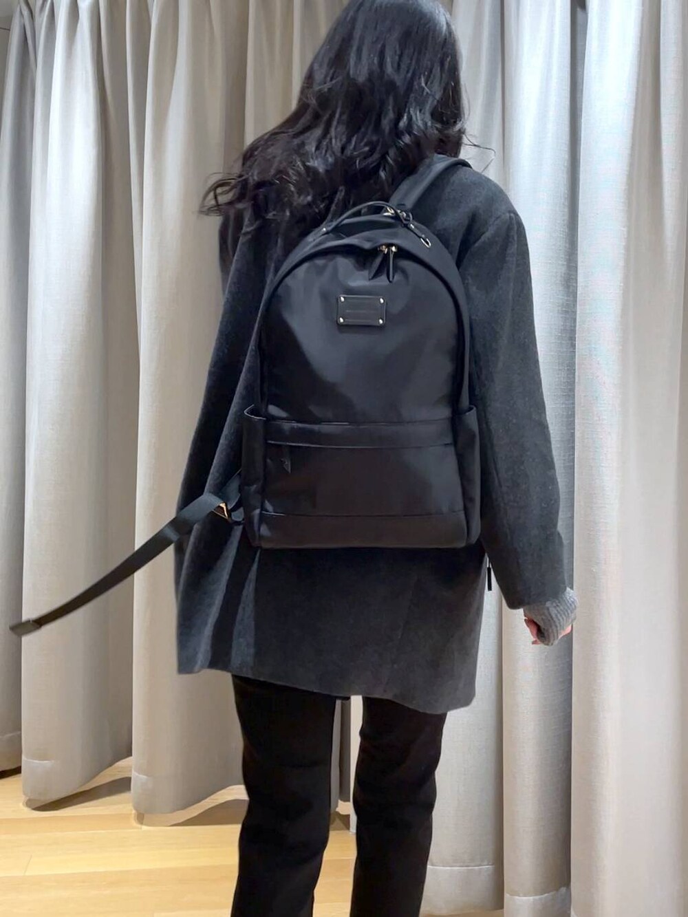 ホワイト系のニット/セーター、ブラック系のデニムパンツ、グレー系のピーコートを着用したレディースの秋コーディネートの4枚目の写真