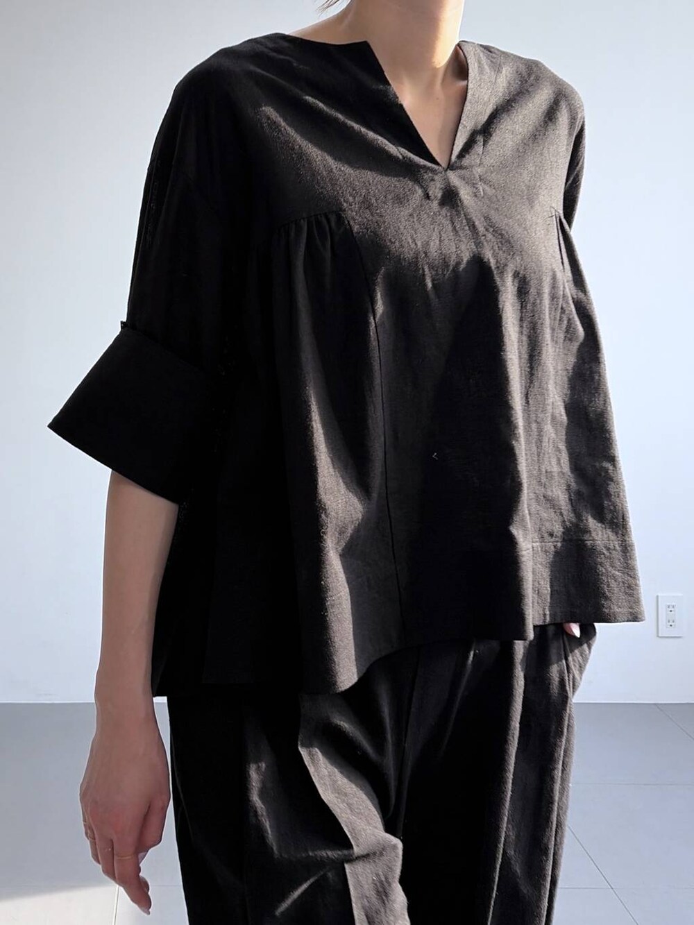 ブラック系のその他パンツ、ブラック系のシャツ/ブラウス、ブラック系のパンプスを着用したレディースの冬コーディネートの5枚目の写真