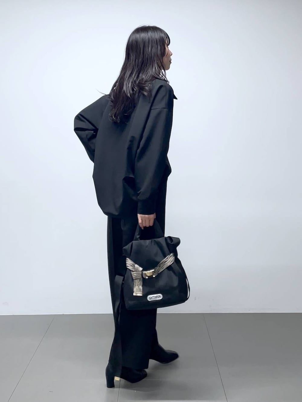 ブラック系のブーツ、ブラック系のシャツ/ブラウス、ブラック系のスラックスを着用したレディースの秋コーディネートの3枚目の写真