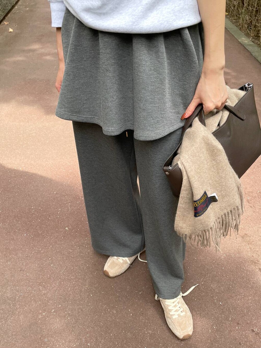 ベージュ系のスニーカー、グレー系のスウェットパンツ、グレー系のスカートを着用したレディースの秋コーディネートの7枚目の写真