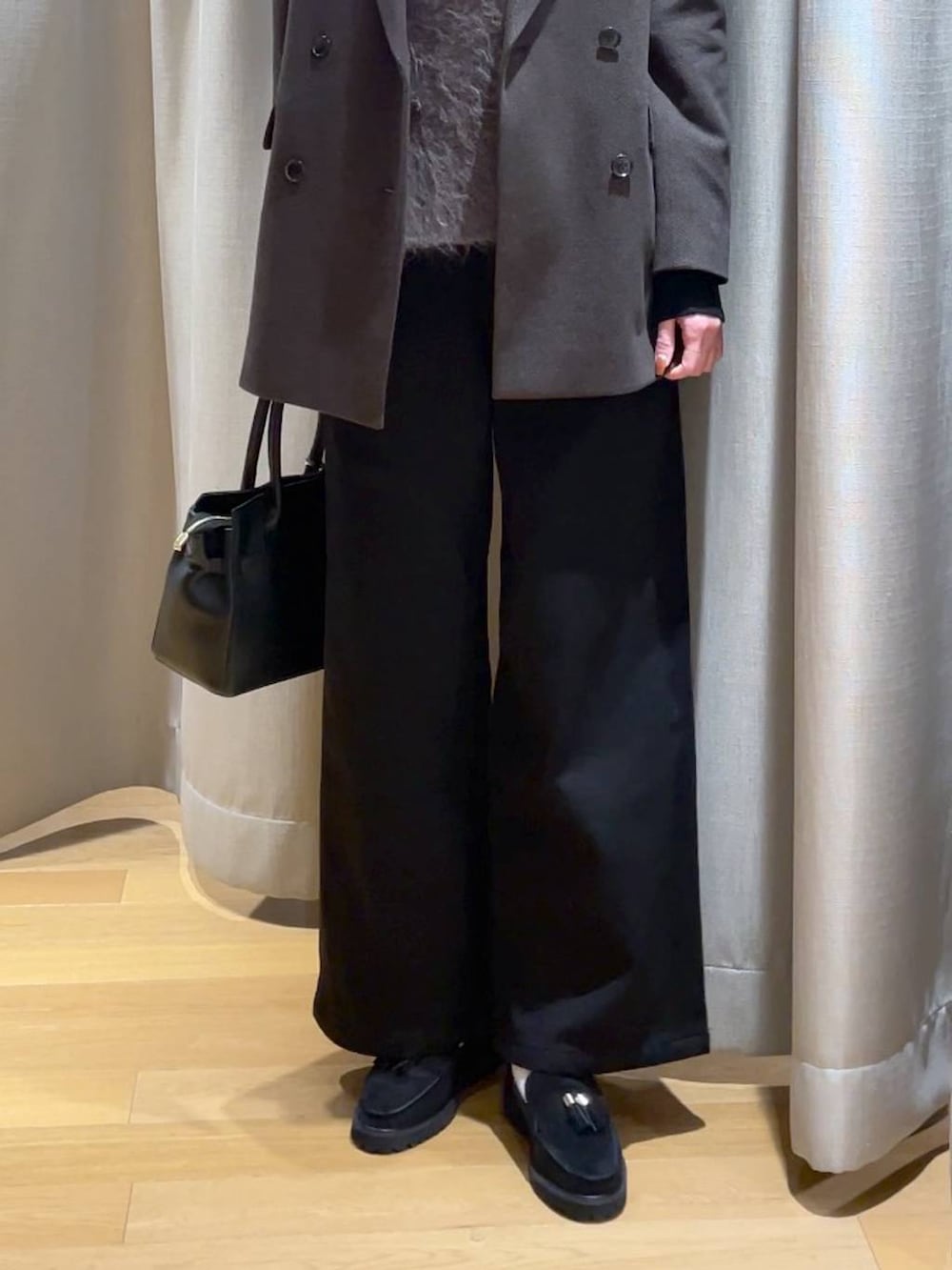 ブラック系のショルダーバッグ、ブラック系のデニムパンツ、ブラック系のTシャツ/カットソーを着用したレディースの秋コーディネートの3枚目の写真