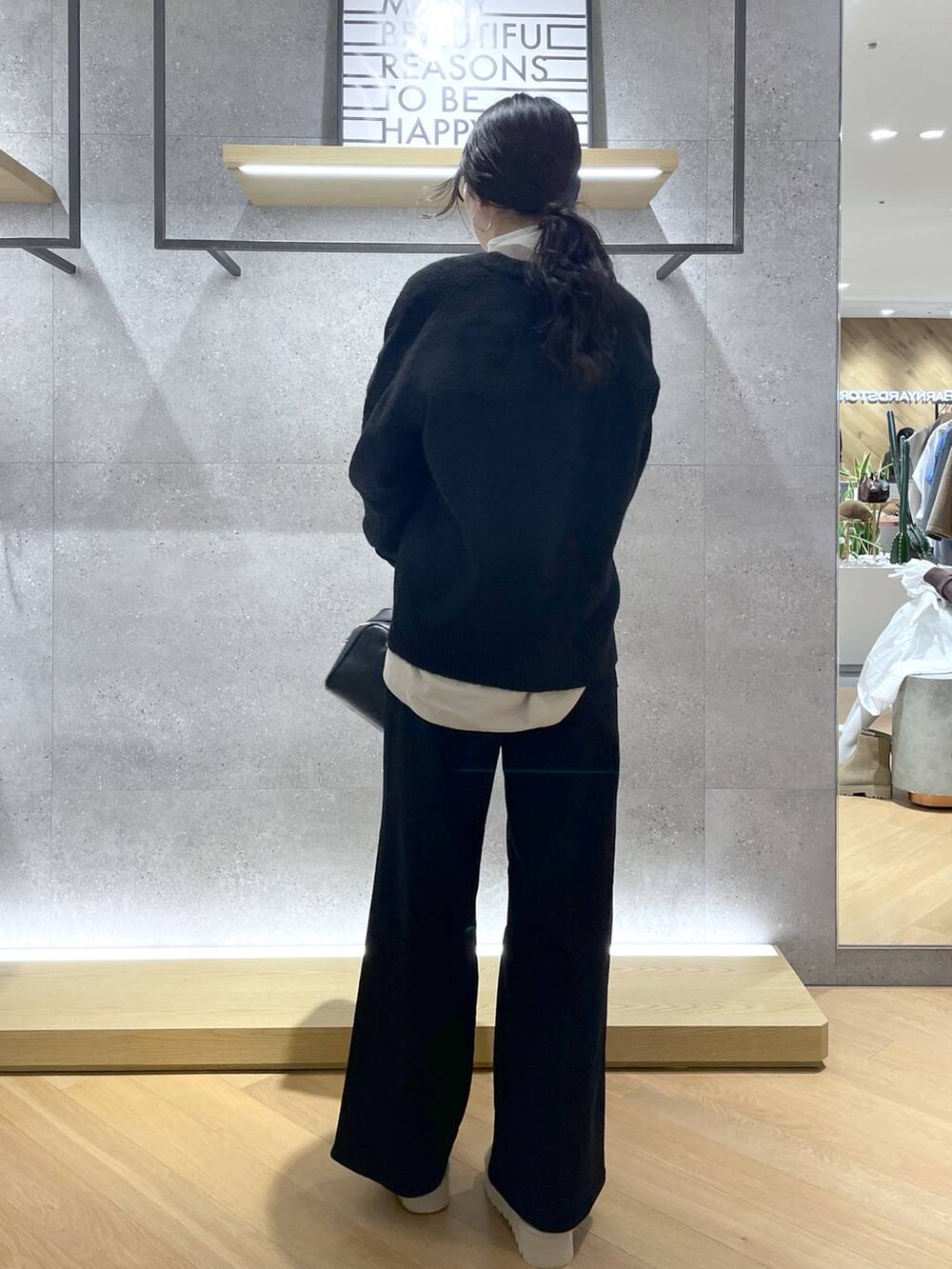 ブラック系のボストンバッグ、ベージュ系のシャツ/ブラウス、ブラック系のデニムパンツを着用したレディースの秋コーディネートの2枚目の写真