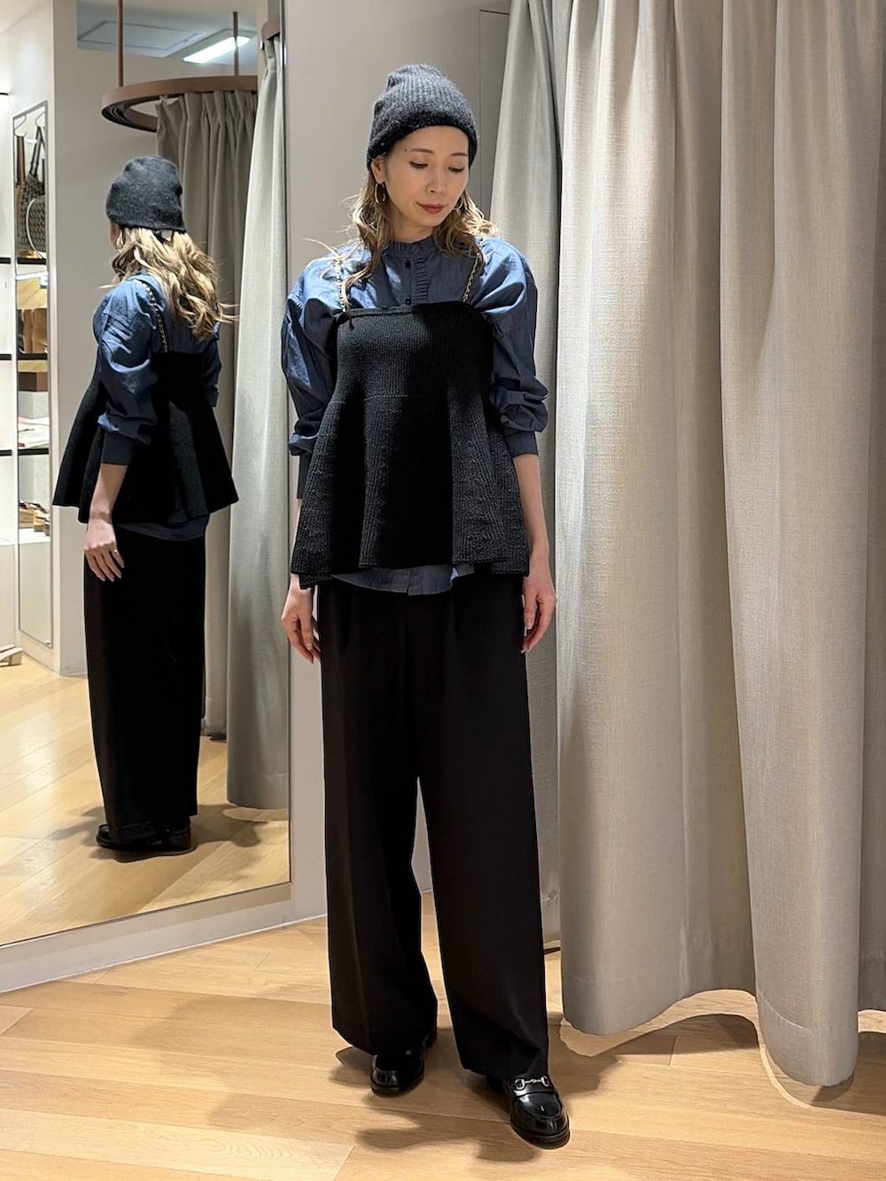 ブルー系のシャツ/ブラウス、ブラック系のニット/セーター、ブラック系のスラックスを着用したレディースの秋コーディネートの3枚目の写真