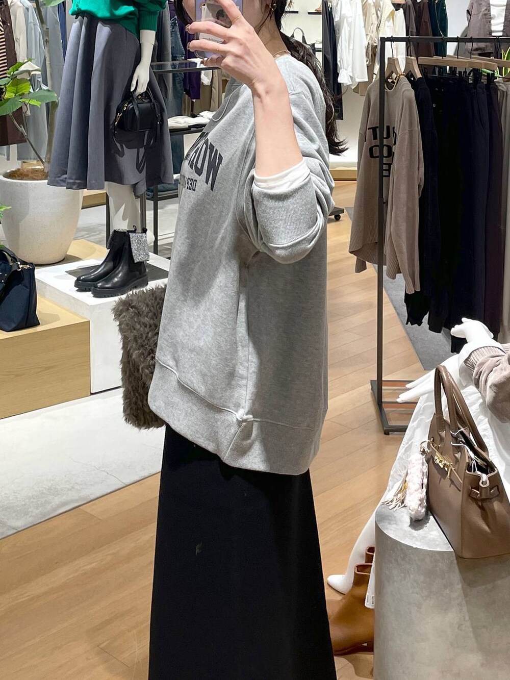 ホワイト系のTシャツ/カットソー、ブラック系のスカート、グレー系のスウェットを着用したレディースの秋コーディネートの6枚目の写真