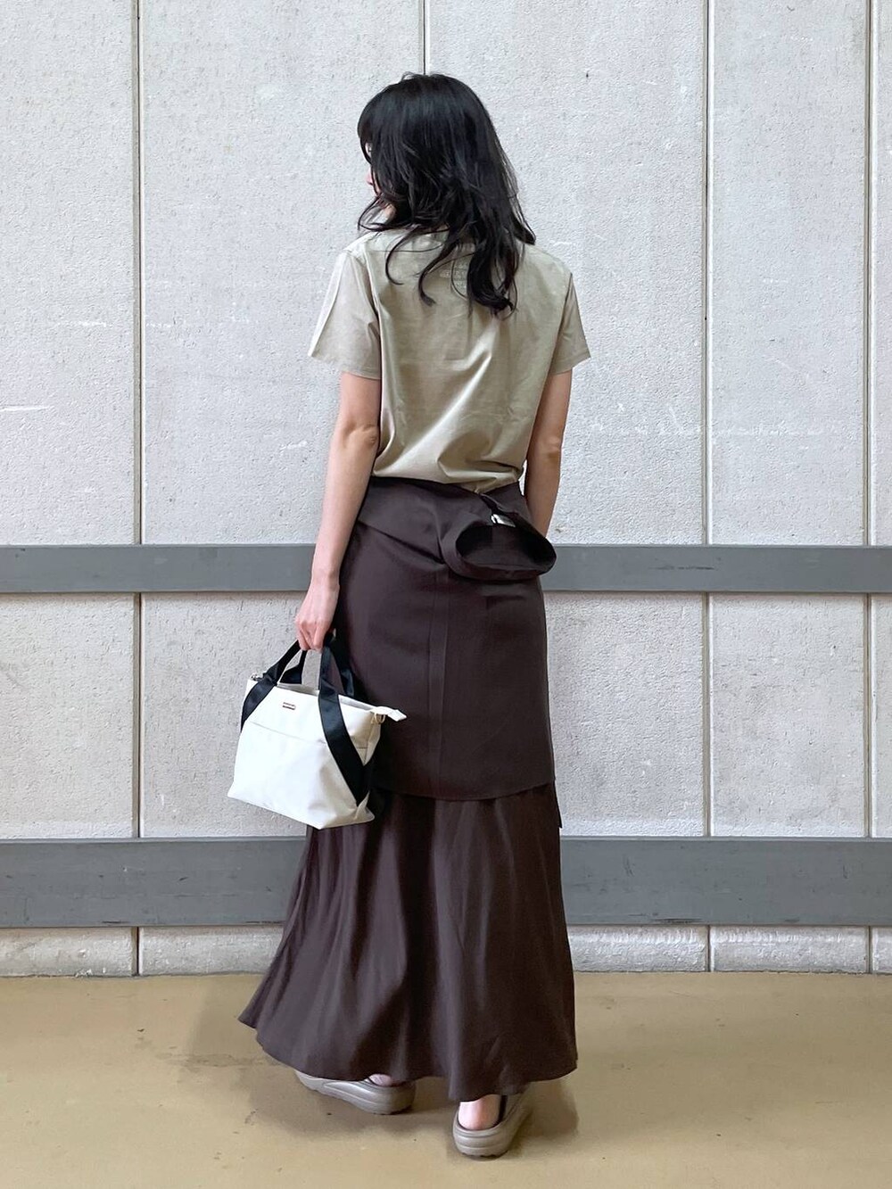 ホワイト系のトートバッグ、ブラウン系のシャツ/ブラウス、イエロー系のTシャツ/カットソーを着用したレディースの夏コーディネートの3枚目の写真