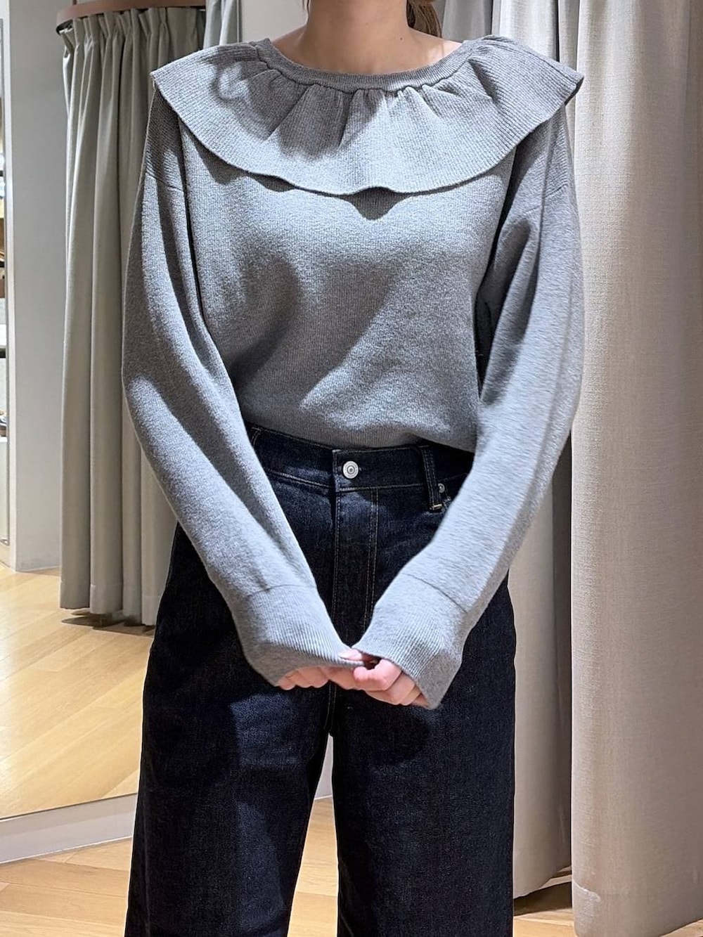 ブルー系のデニムパンツ、ブラウン系のショルダーバッグ、グレー系のニット/セーターを着用したレディースの冬コーディネートの5枚目の写真