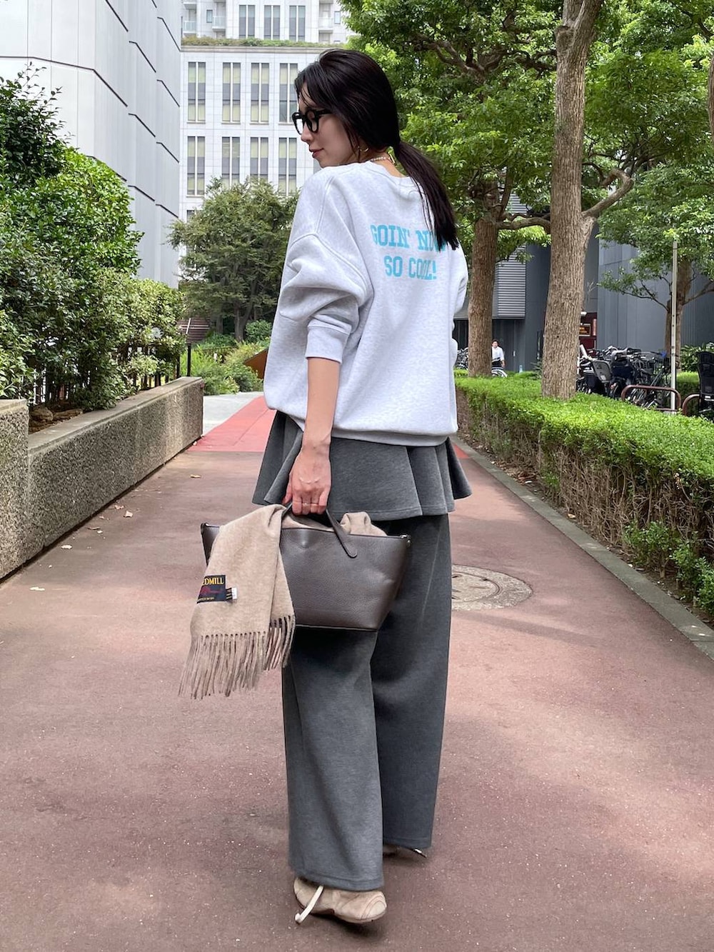 ベージュ系のスニーカー、グレー系のスウェットパンツ、グレー系のスカートを着用したレディースの秋コーディネートの3枚目の写真