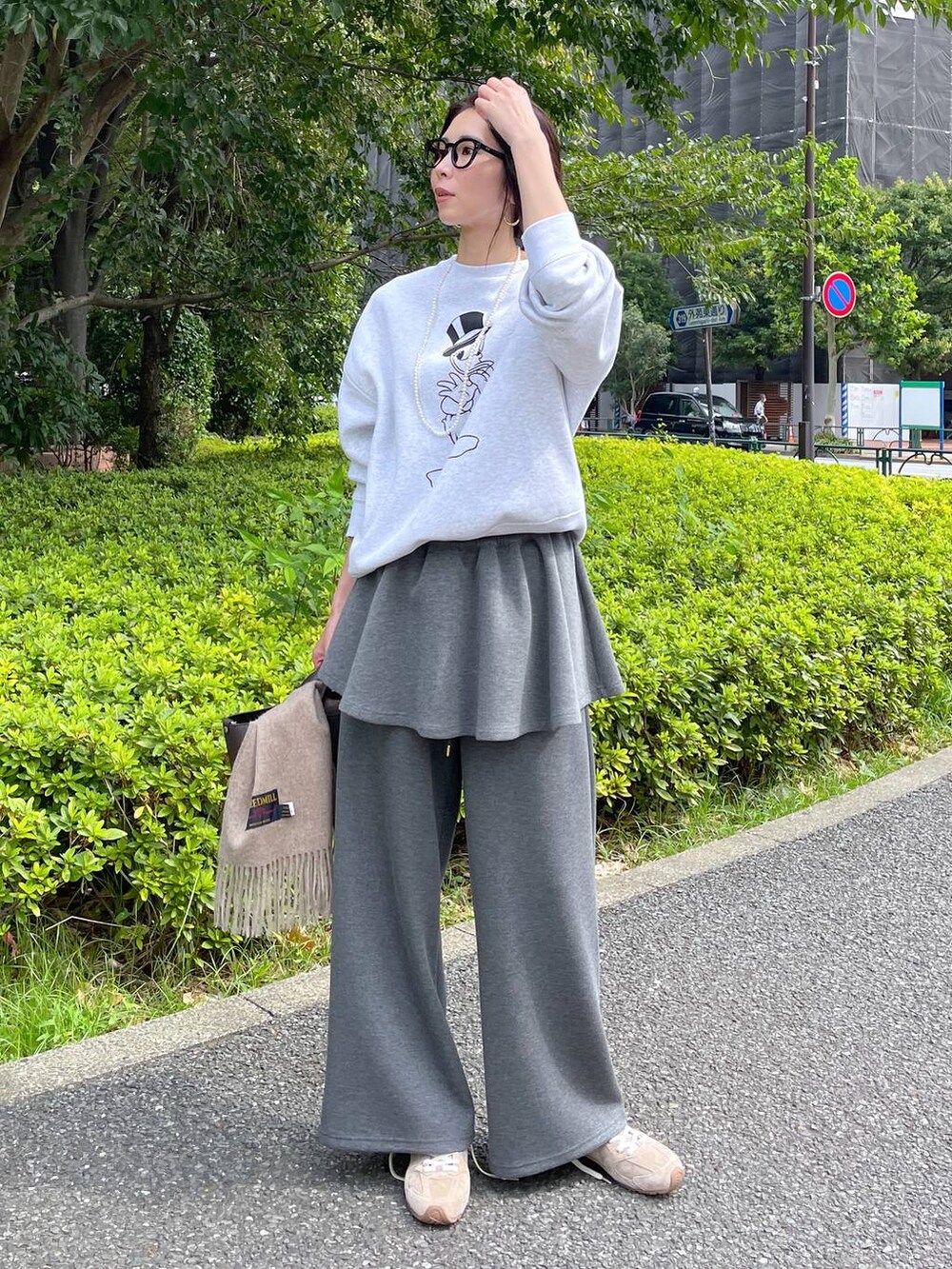 ベージュ系のスニーカー、グレー系のスウェットパンツ、グレー系のスカートを着用したレディースの秋コーディネートの2枚目の写真