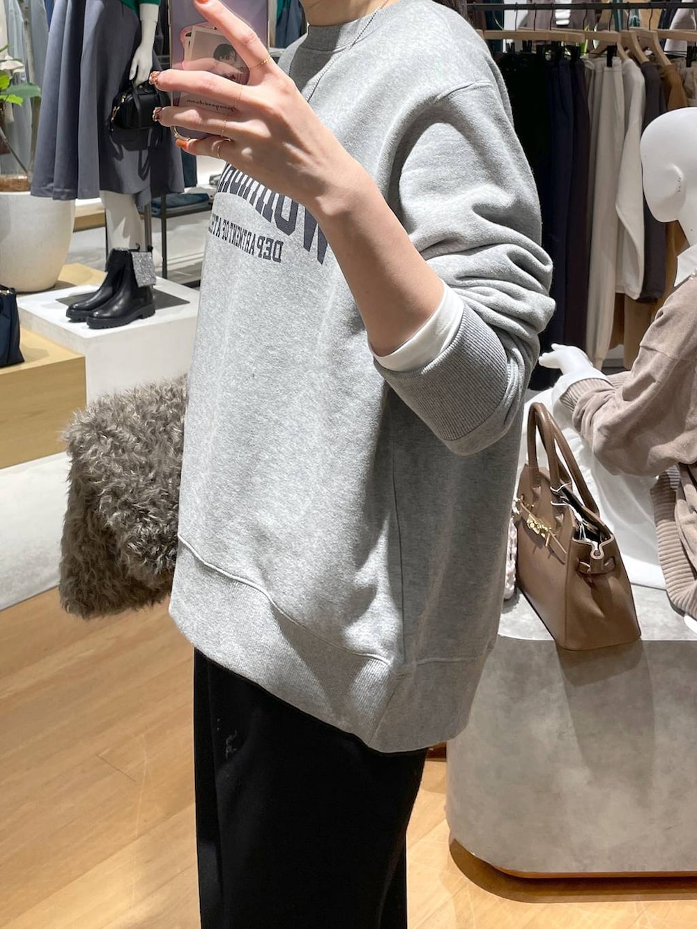 ホワイト系のTシャツ/カットソー、ブラック系のスカート、グレー系のスウェットを着用したレディースの秋コーディネートの5枚目の写真