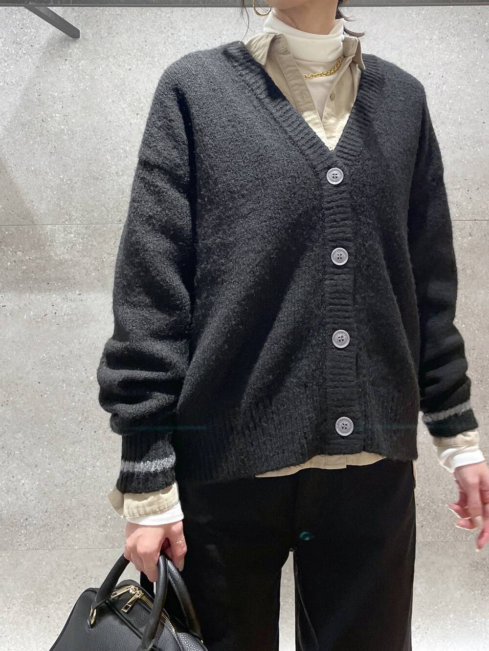 ブラック系のボストンバッグ、ベージュ系のシャツ/ブラウス、ブラック系のデニムパンツを着用したレディースの秋コーディネートの8枚目の写真