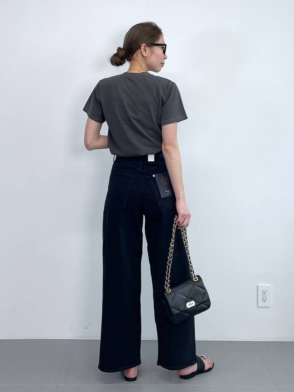 ブルー系のデニムパンツ、グレー系のTシャツ/カットソー、ゴールド系のネックレスを着用したレディースの春コーディネートの3枚目の写真