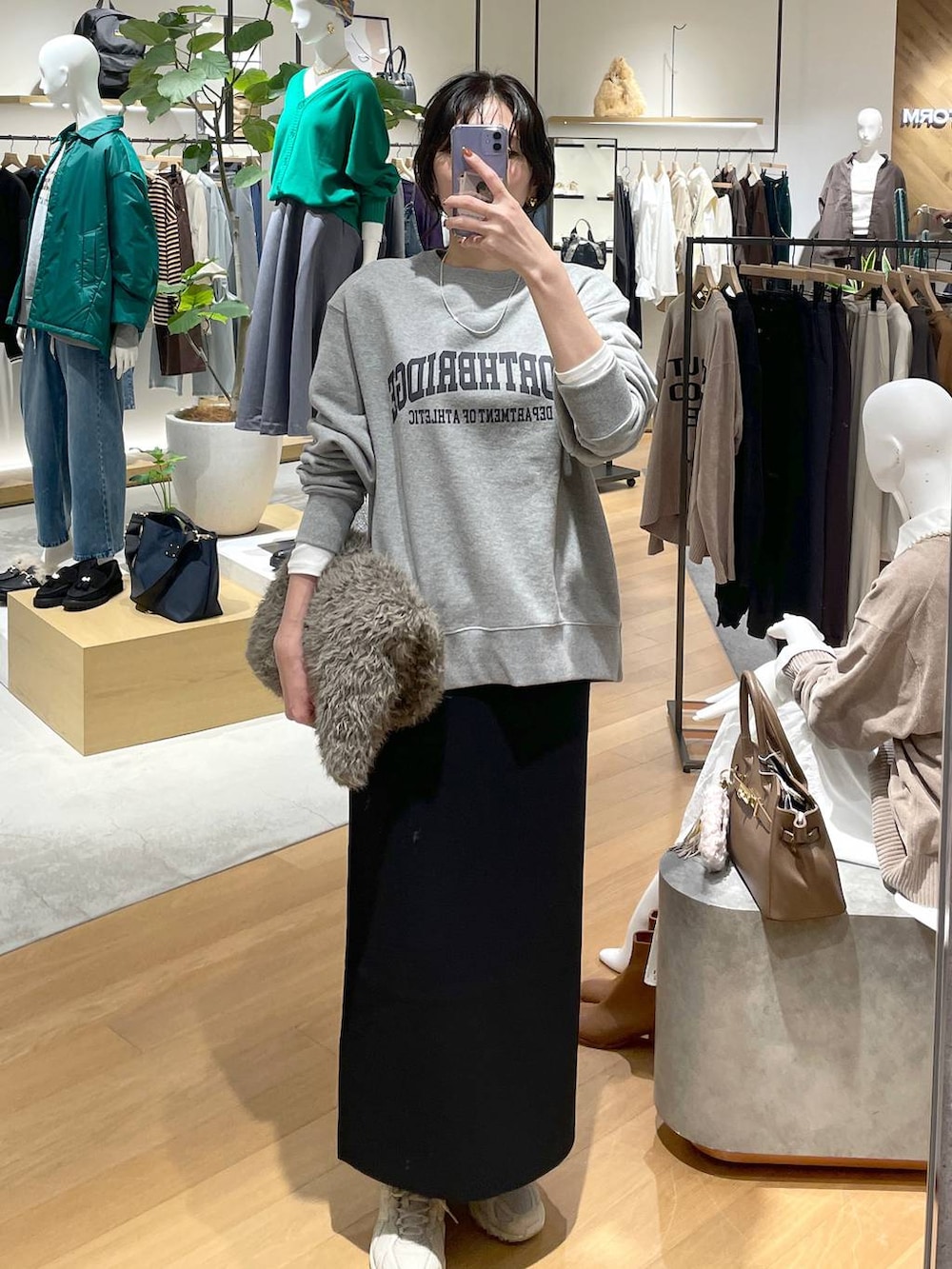 ホワイト系のTシャツ/カットソー、ブラック系のスカート、グレー系のスウェットを着用したレディースの秋コーディネートの2枚目の写真
