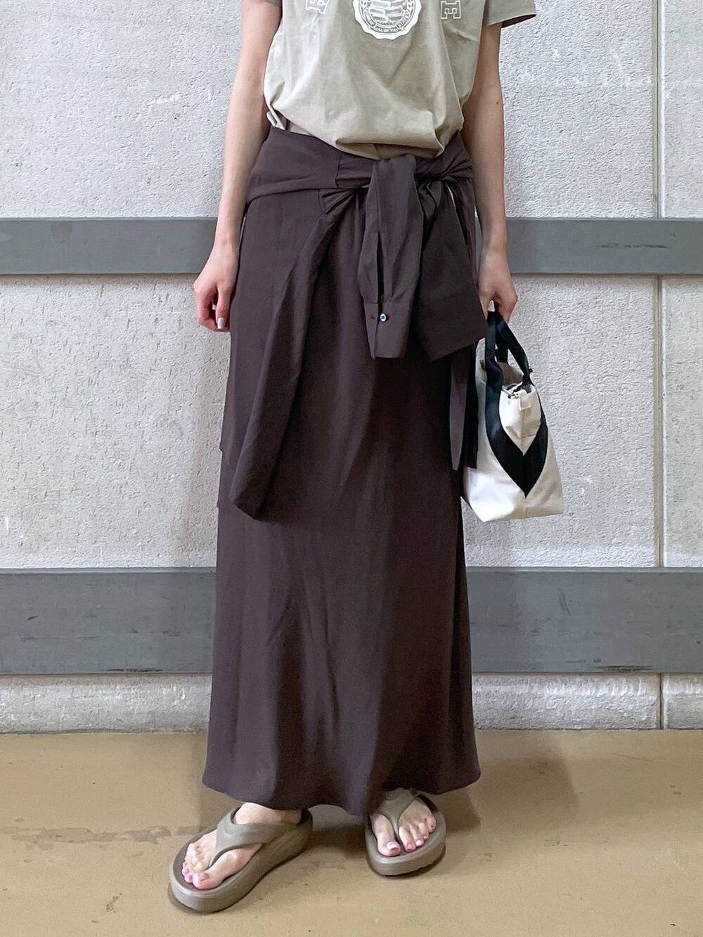 ホワイト系のトートバッグ、ブラウン系のシャツ/ブラウス、イエロー系のTシャツ/カットソーを着用したレディースの夏コーディネートの2枚目の写真