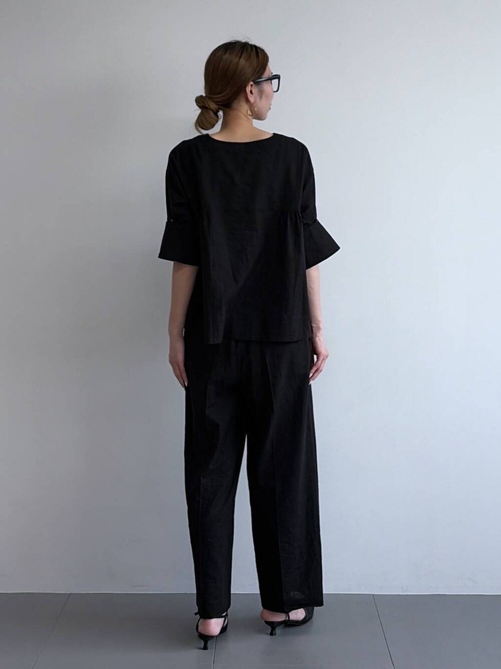 ブラック系のその他パンツ、ブラック系のシャツ/ブラウス、ブラック系のパンプスを着用したレディースの冬コーディネートの3枚目の写真