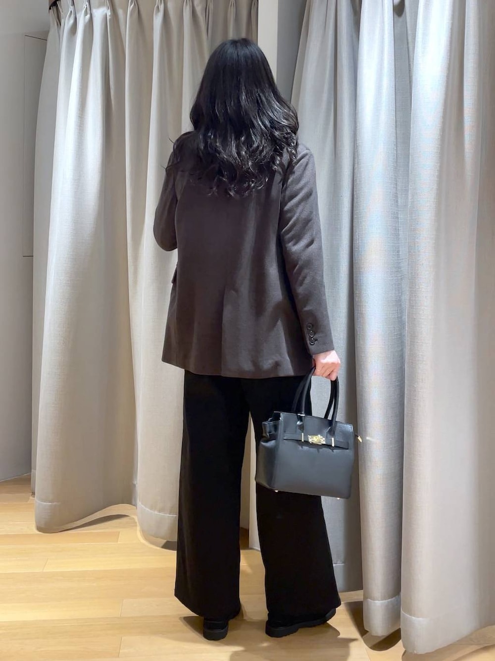 ブラック系のショルダーバッグ、ブラック系のデニムパンツ、ブラック系のTシャツ/カットソーを着用したレディースの秋コーディネートの2枚目の写真