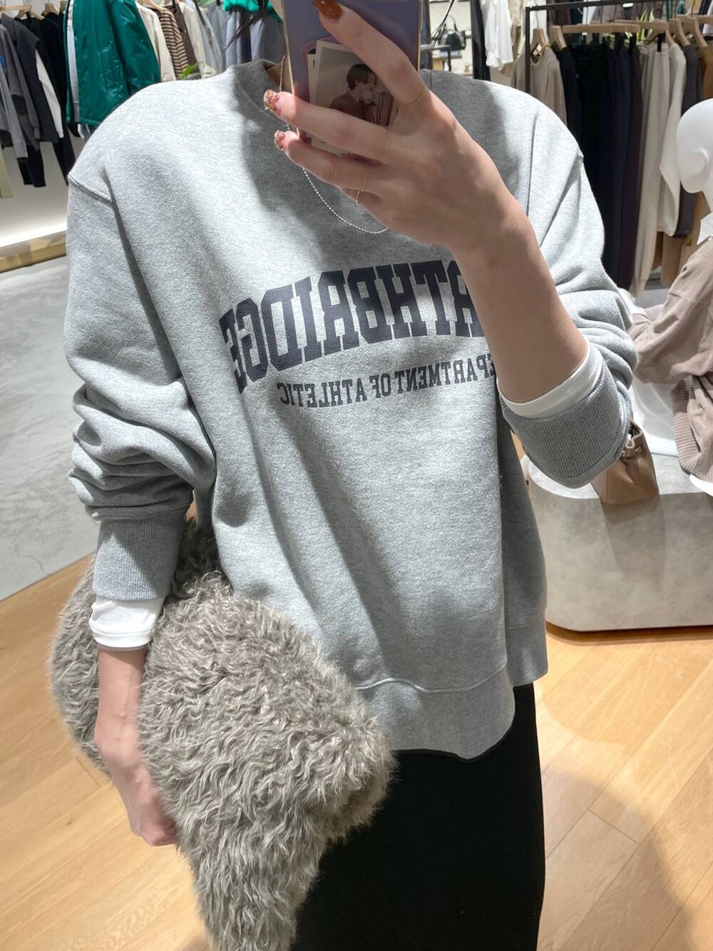 ホワイト系のTシャツ/カットソー、ブラック系のスカート、グレー系のスウェットを着用したレディースの秋コーディネートの4枚目の写真