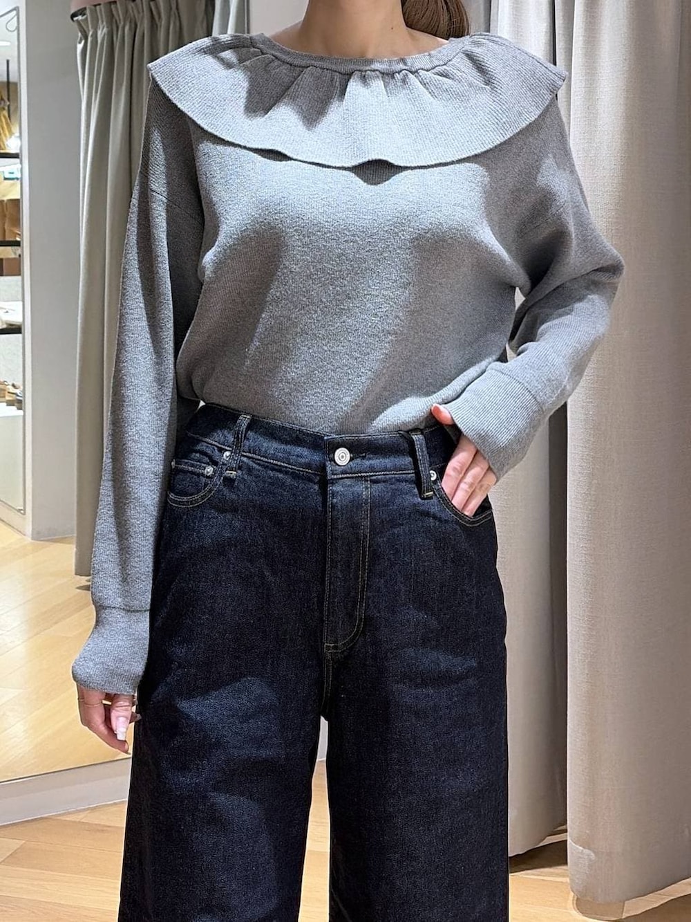 ブルー系のデニムパンツ、ブラウン系のショルダーバッグ、グレー系のニット/セーターを着用したレディースの冬コーディネートの6枚目の写真