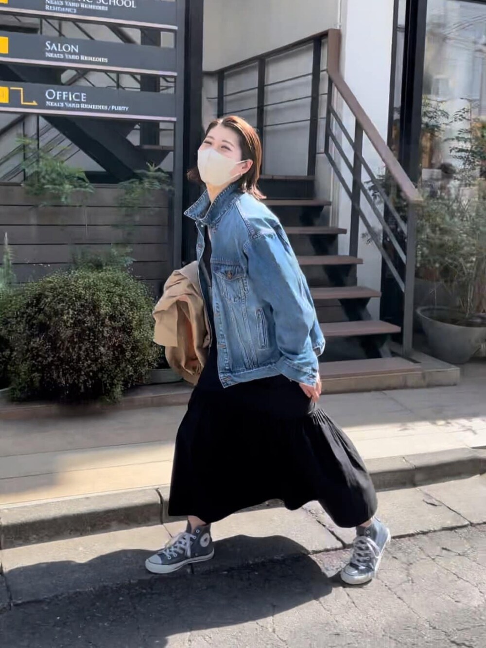 ブルー系のデニムジャケット、ブラック系のワンピース、グリーン系のモッズコートを着用したレディースの春コーディネートの5枚目の写真