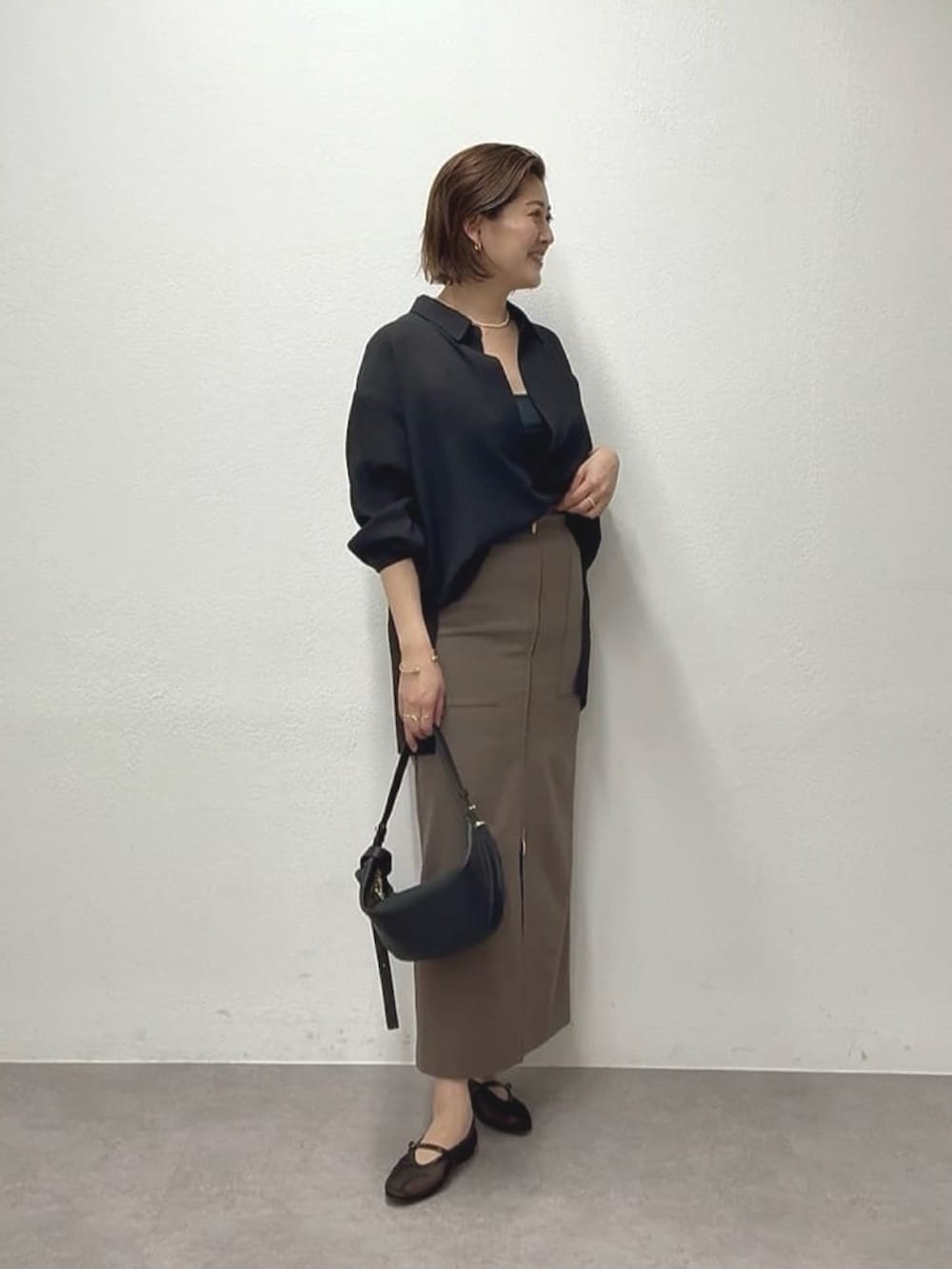 ブラック系のシャツ/ブラウス、ブラウン系のスカート、ブラック系のショルダーバッグを着用したレディースの春コーディネートの3枚目の写真
