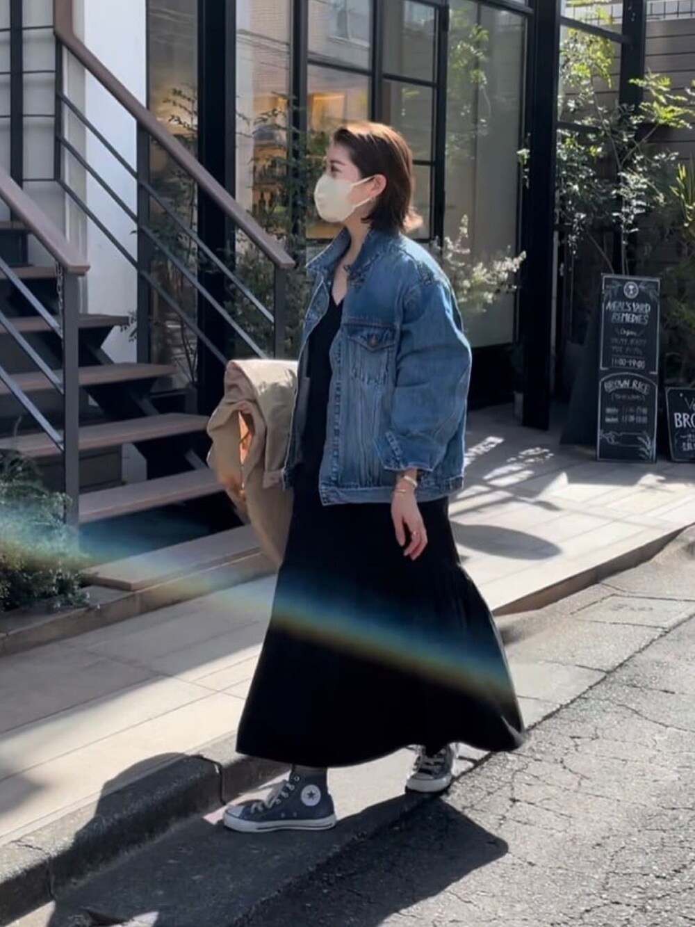 ブルー系のデニムジャケット、ブラック系のワンピース、グリーン系のモッズコートを着用したレディースの春コーディネートの2枚目の写真