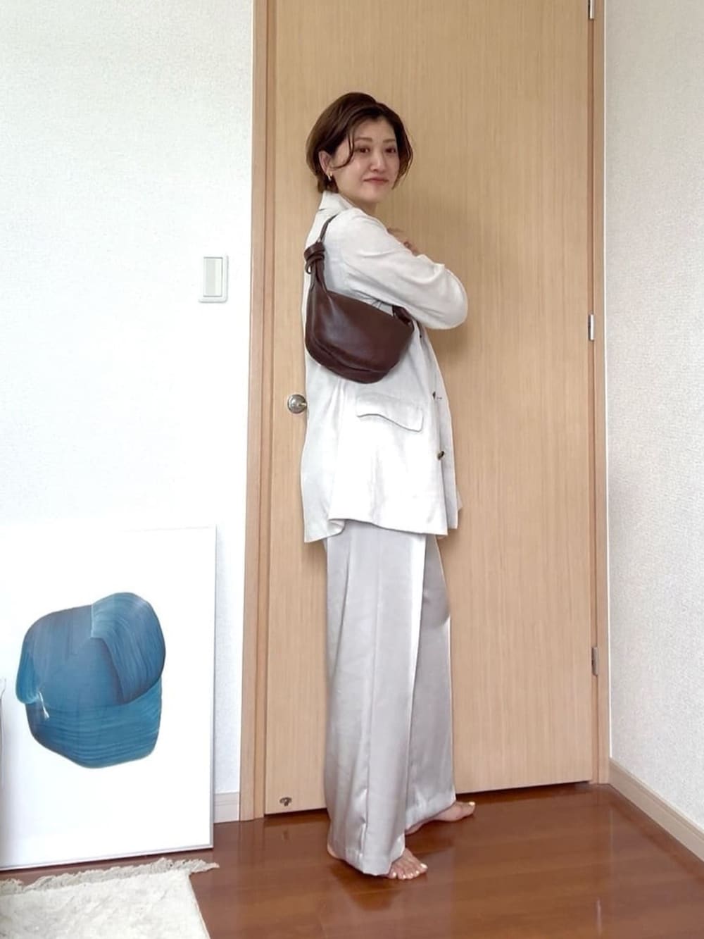 ベージュ系のキャミソール、ベージュ系のその他パンツ、ブラウン系のショルダーバッグを着用したレディースの夏コーディネートの2枚目の写真