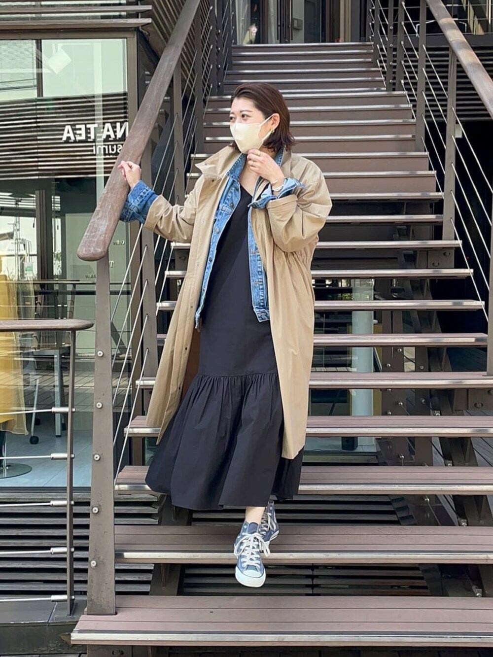 ブルー系のデニムジャケット、ブラック系のワンピース、グリーン系のモッズコートを着用したレディースの春コーディネートの4枚目の写真