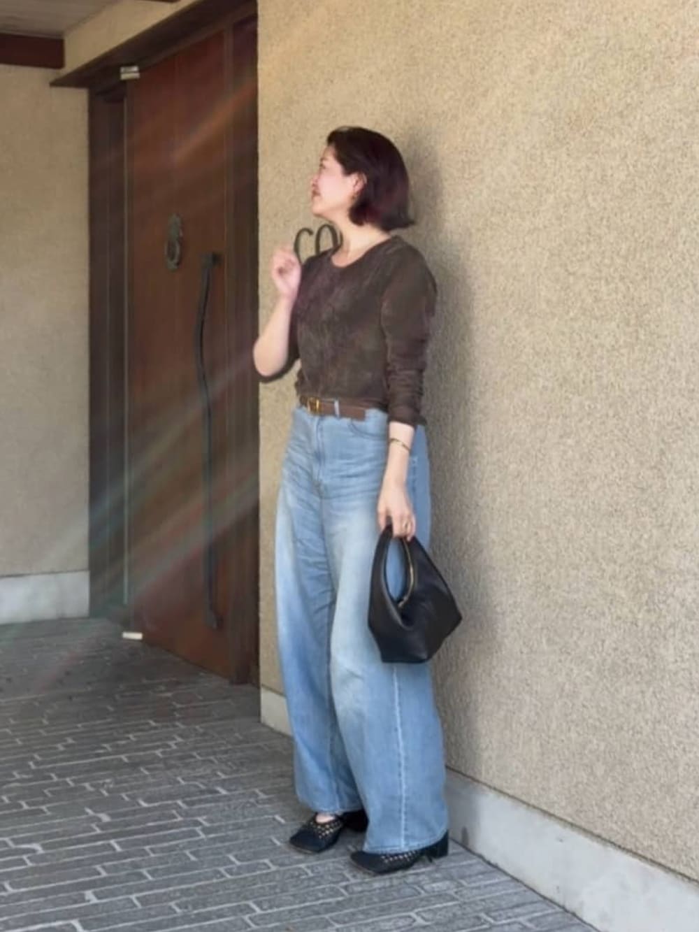 ブラウン系のTシャツ/カットソー、ブルー系のデニムパンツ、ブラウン系のベルトを着用したレディースの秋コーディネートの3枚目の写真