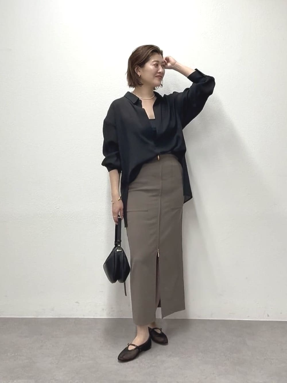 ブラック系のシャツ/ブラウス、ブラウン系のスカート、ブラック系のショルダーバッグを着用したレディースの春コーディネートの2枚目の写真