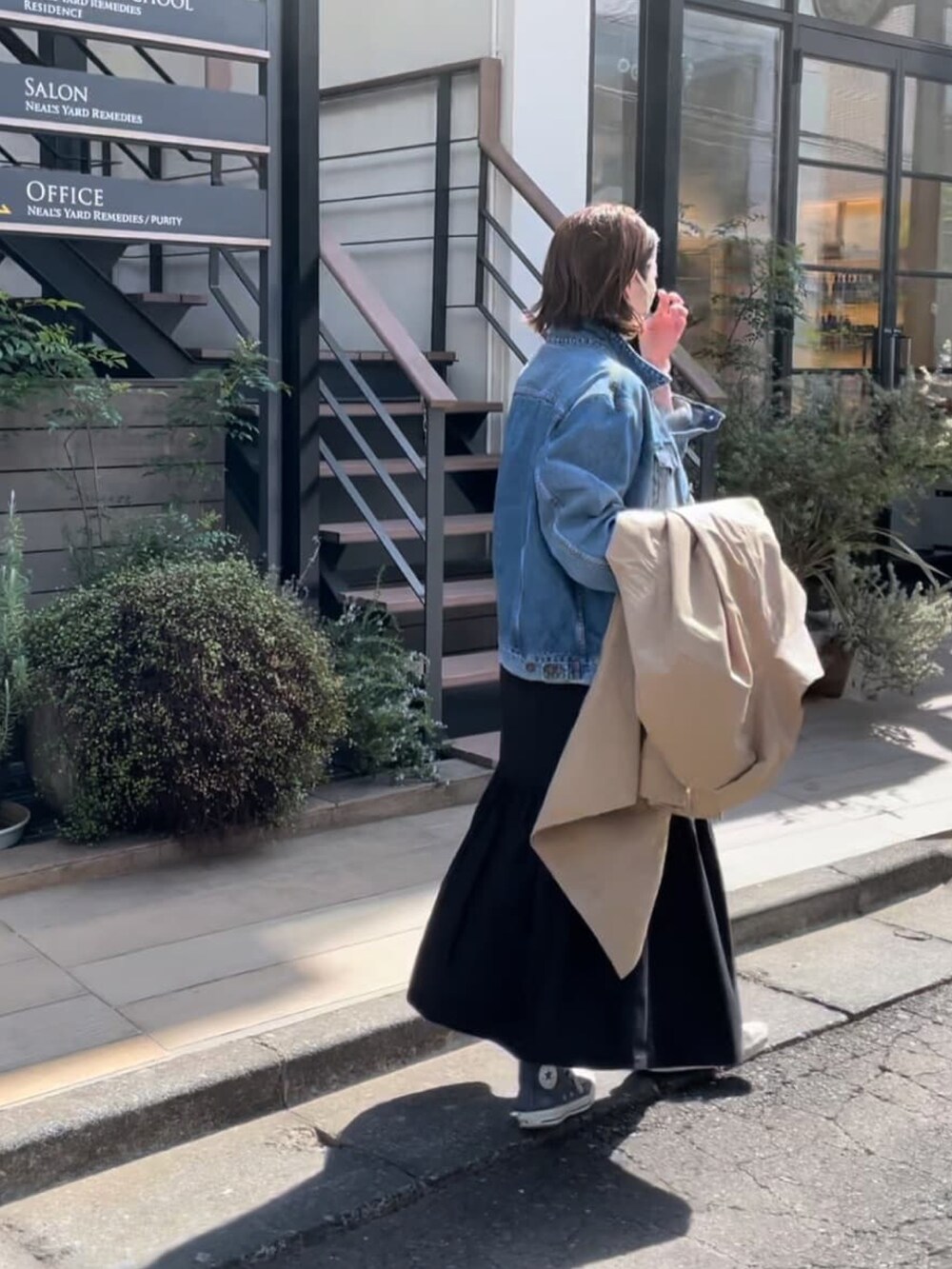 ブルー系のデニムジャケット、ブラック系のワンピース、グリーン系のモッズコートを着用したレディースの春コーディネートの3枚目の写真