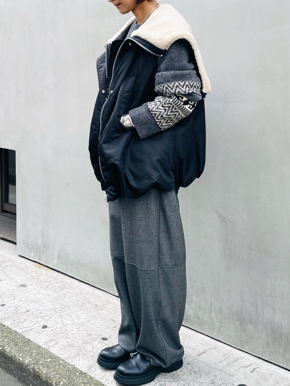 ブラック系のその他アウター、グレー系のニット/セーター、グレー系のその他パンツを着用したレディースの秋コーディネートの2枚目の写真