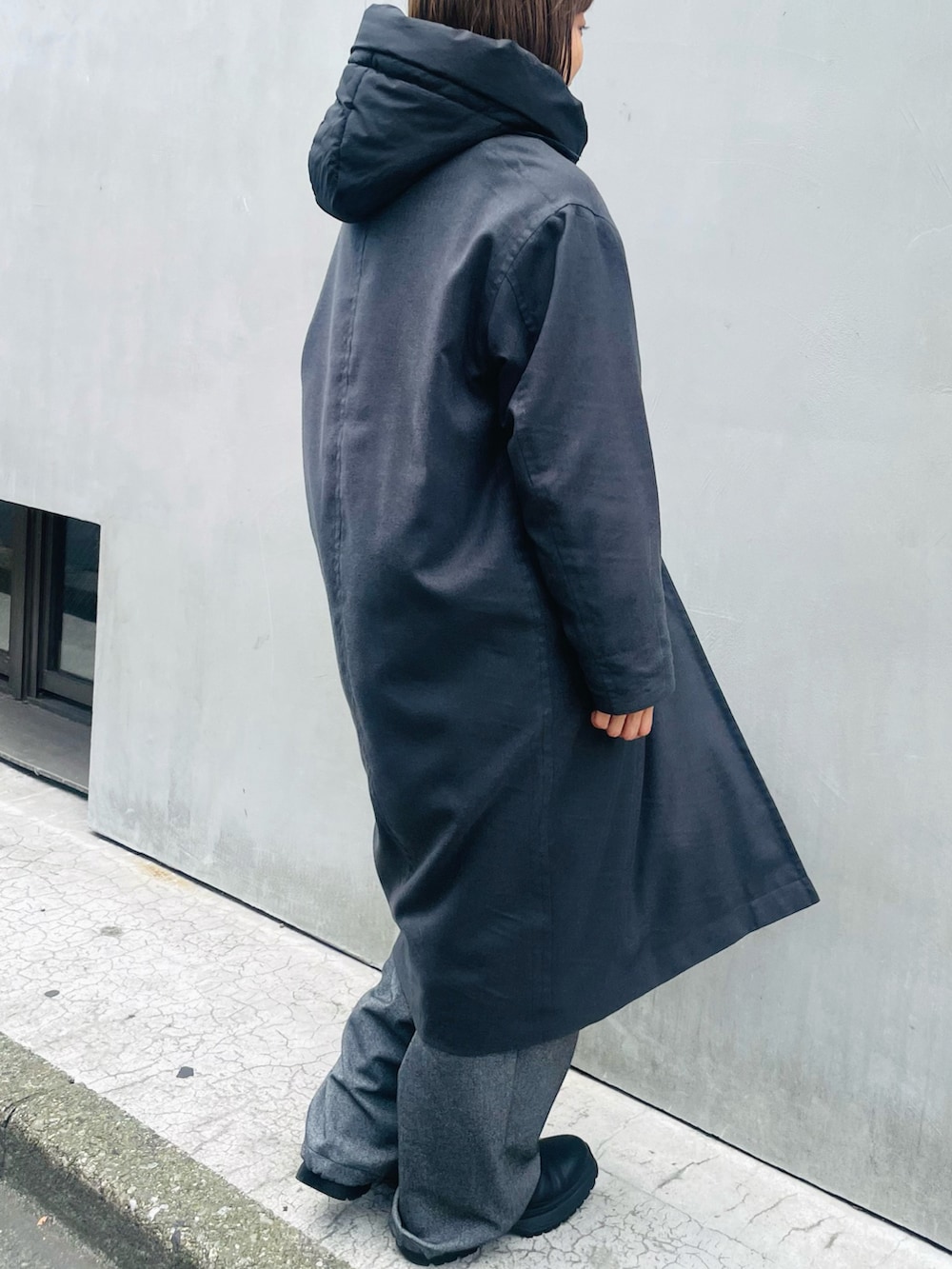 グレー系のステンカラーコート、グレー系のその他パンツ、ブラック系のブーツを着用したレディースの冬コーディネートの2枚目の写真