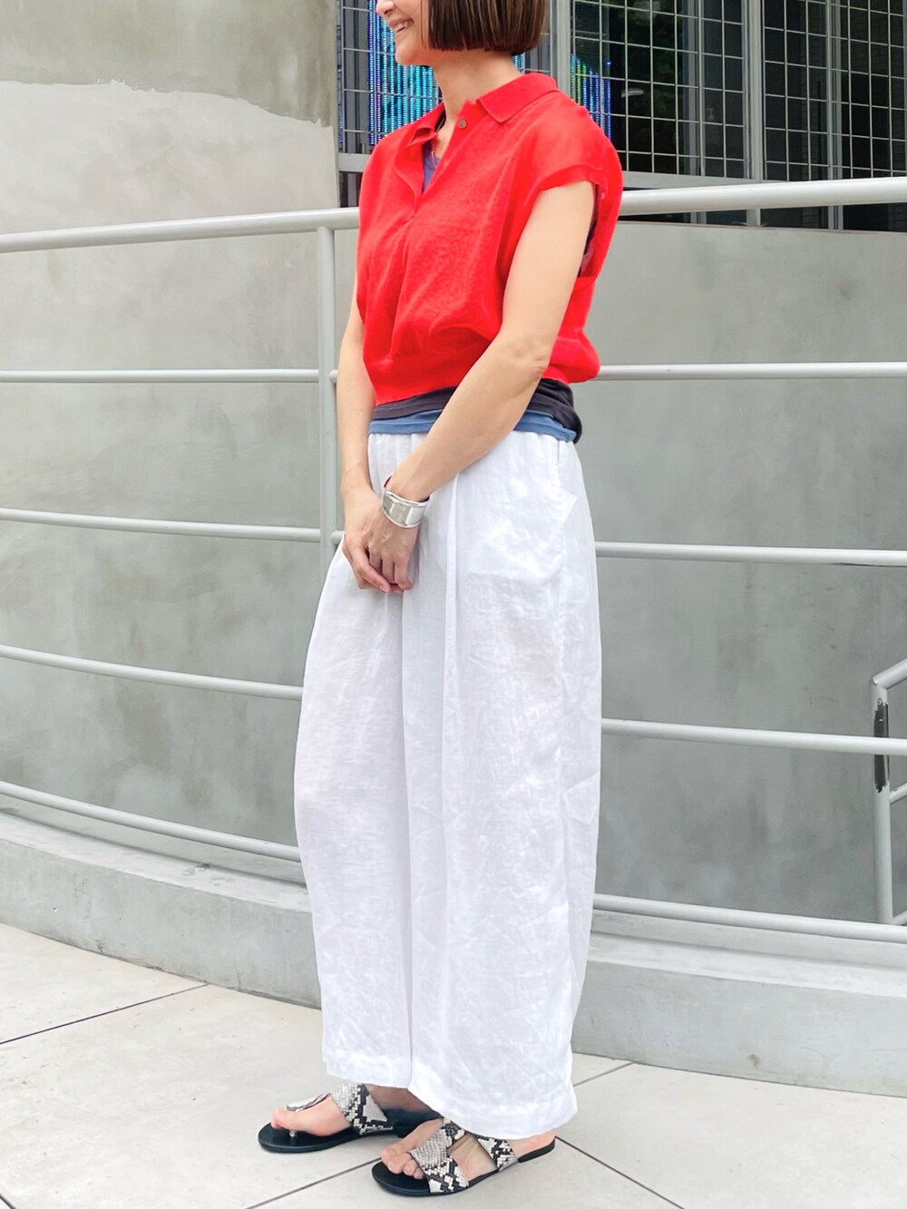 レッド系のニット/セーター、ホワイト系のその他パンツ、グレー系のタンクトップを着用したレディースの夏コーディネートの2枚目の写真