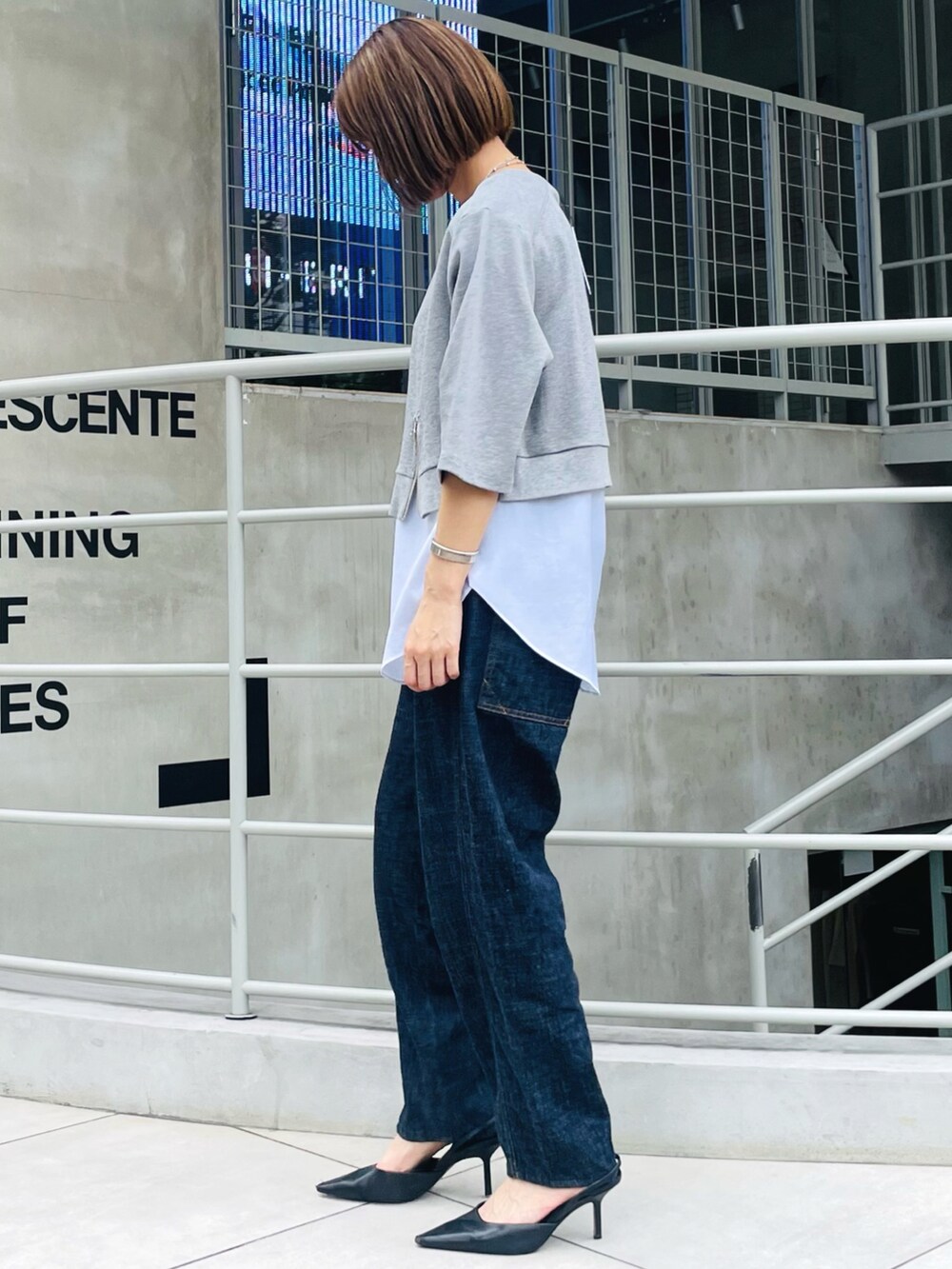 グレー系のTシャツ/カットソー、ブルー系のデニムパンツ、ブラック系のパンプスを着用したレディースの夏コーディネートの2枚目の写真