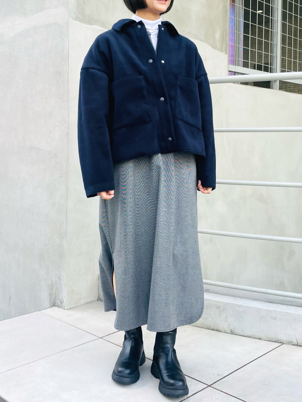 ブルー系のブルゾン、ブラック系のワンピース、ホワイト系のTシャツ/カットソーを着用したレディースの冬コーディネートの2枚目の写真