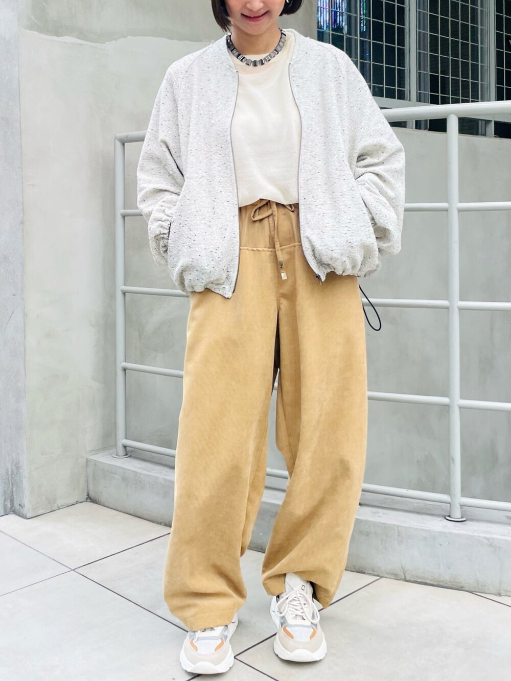 ホワイト系のブルゾン、イエロー系のその他パンツ、ベージュ系のTシャツ/カットソーを着用したレディースの秋コーディネートの2枚目の写真