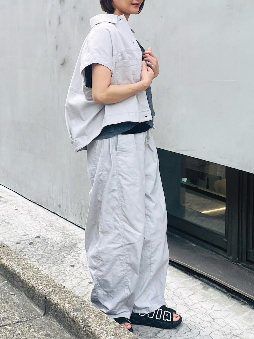 ブラウン系のベスト、グレー系のデニムパンツ、グレー系のベストを着用したレディースの夏コーディネートの2枚目の写真