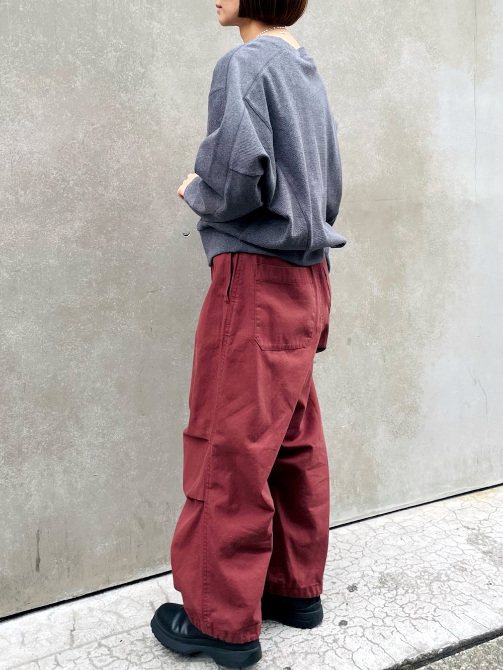 レッド系のその他パンツ、ブラック系のブーツを着用したレディースの冬コーディネートの2枚目の写真