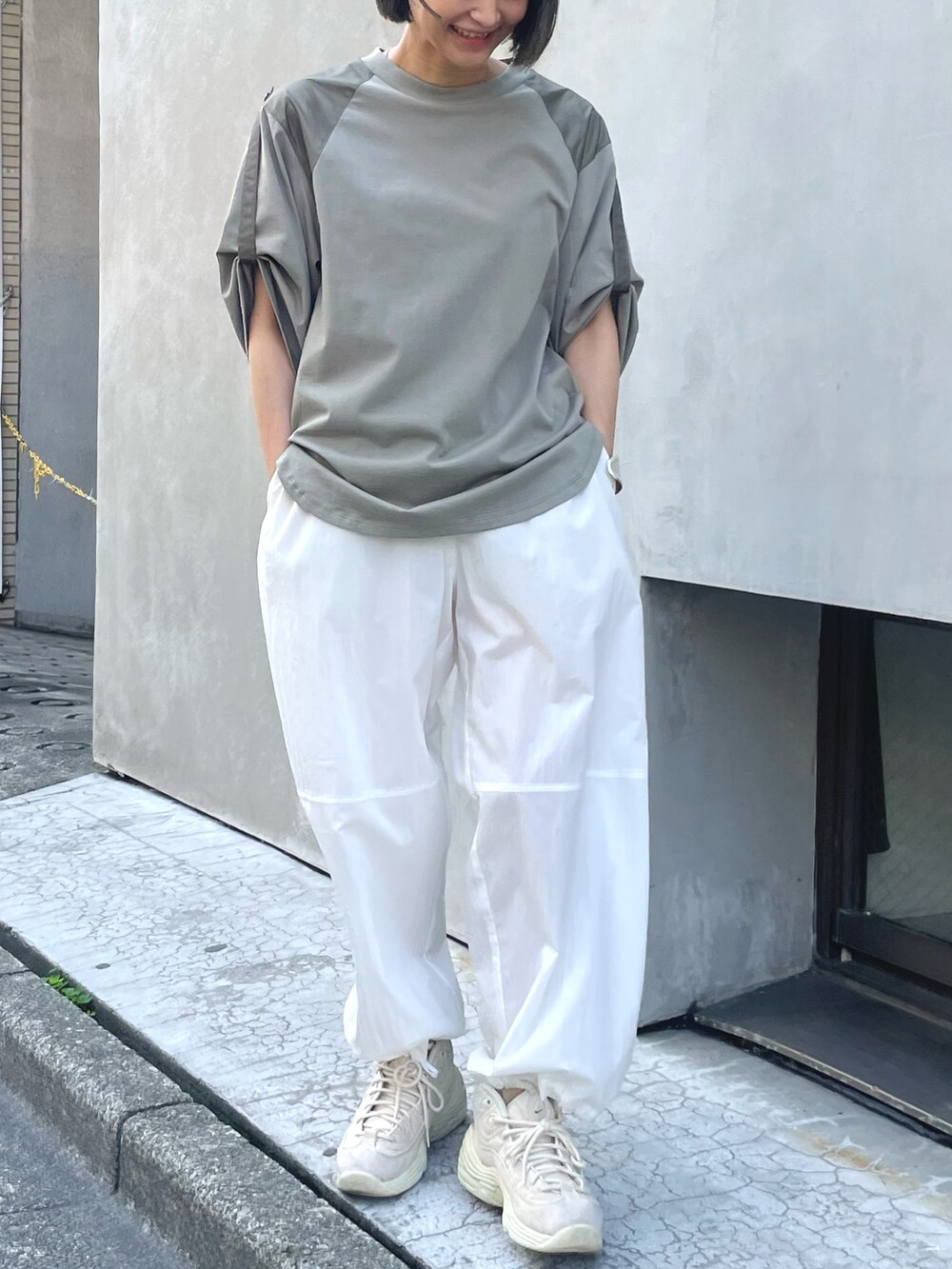 グリーン系のTシャツ/カットソー、ホワイト系のその他パンツ、ホワイト系のスニーカーを着用したレディースの夏コーディネートの2枚目の写真