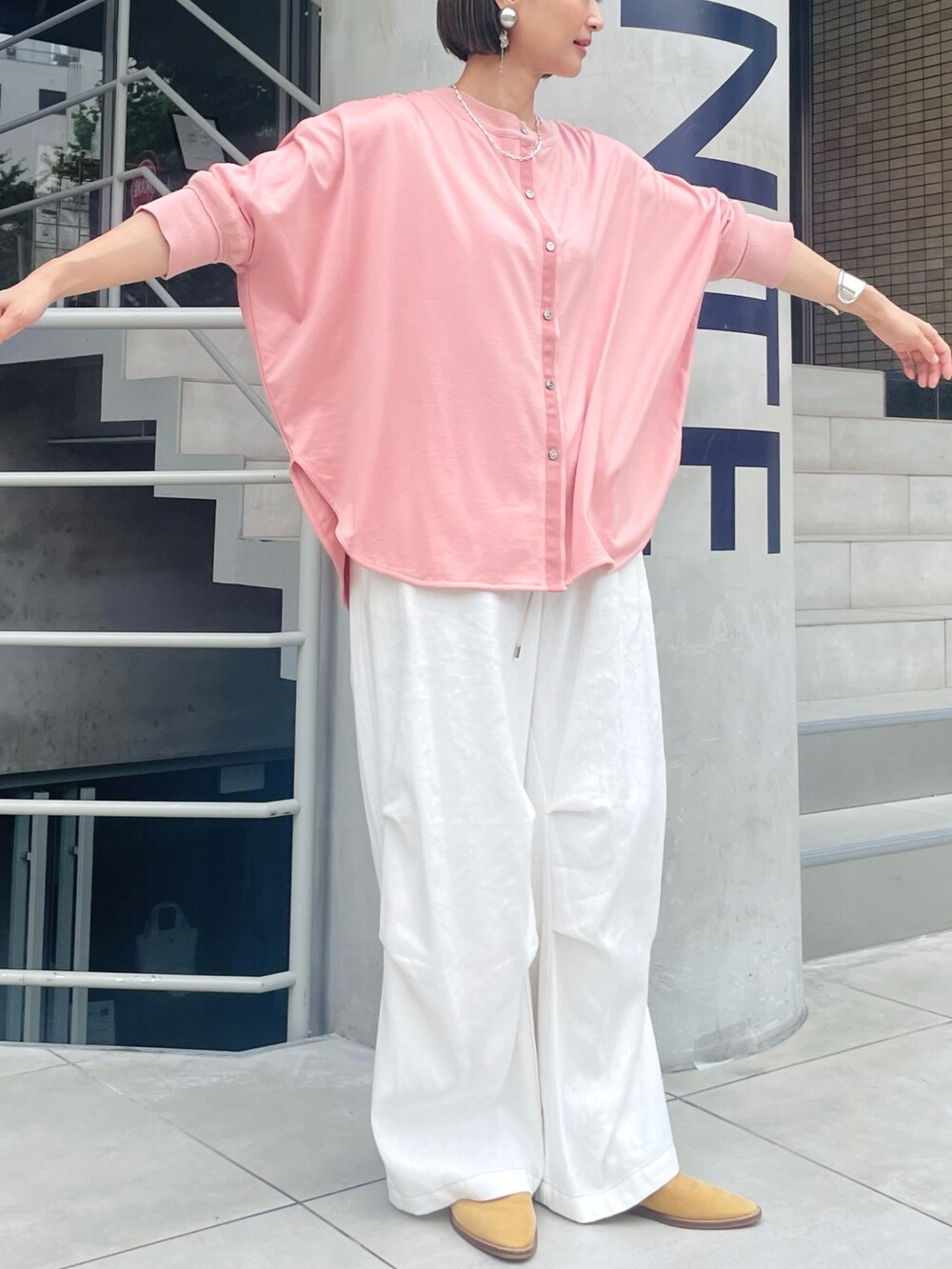 ピンク系のシャツ/ブラウス、ホワイト系のその他パンツ、ベージュ系のサンダルを着用したレディースの夏コーディネートの2枚目の写真